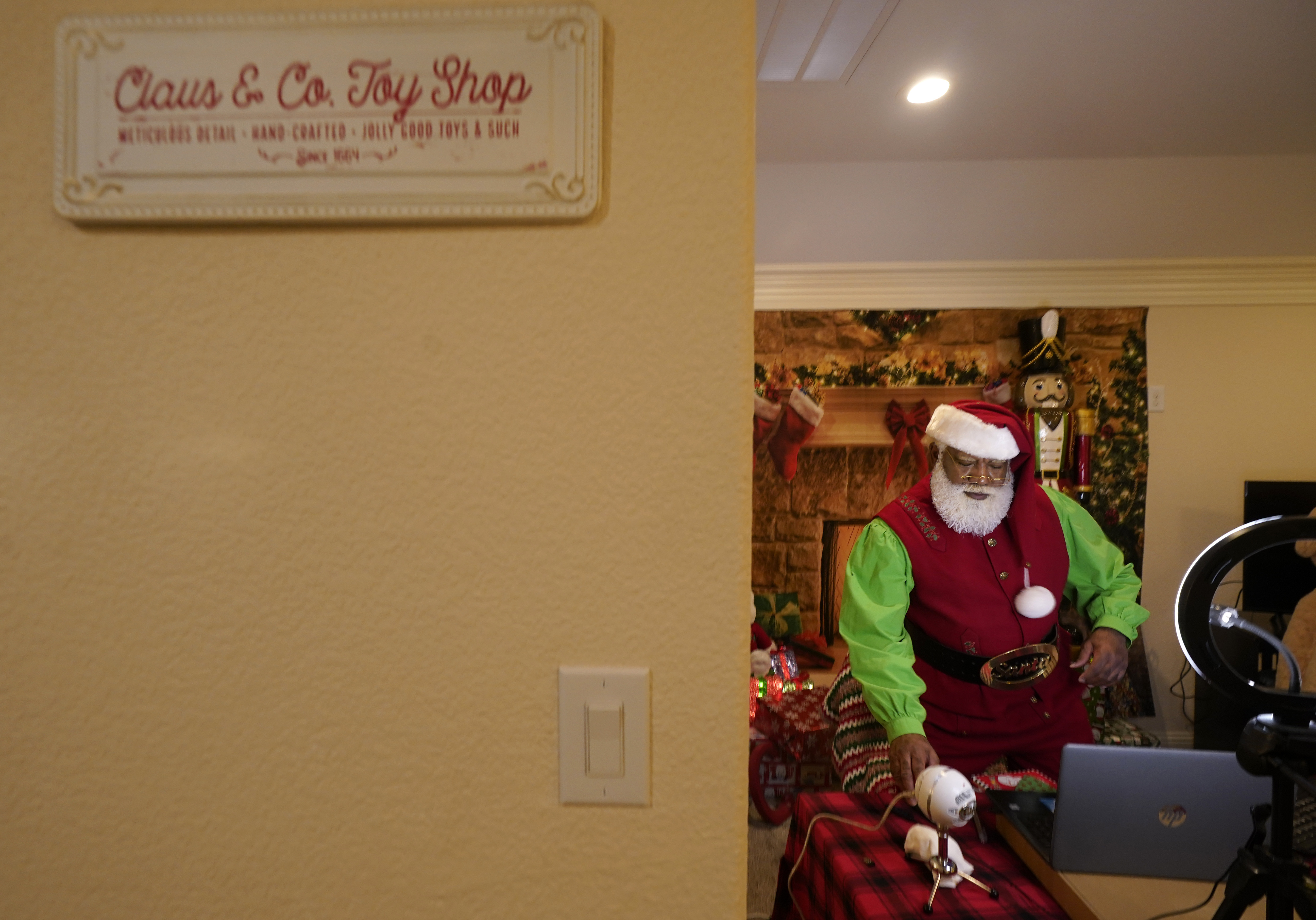Larry Jefferson as Santa Claus sits in an office labelled Claus & Co. Toy Shop