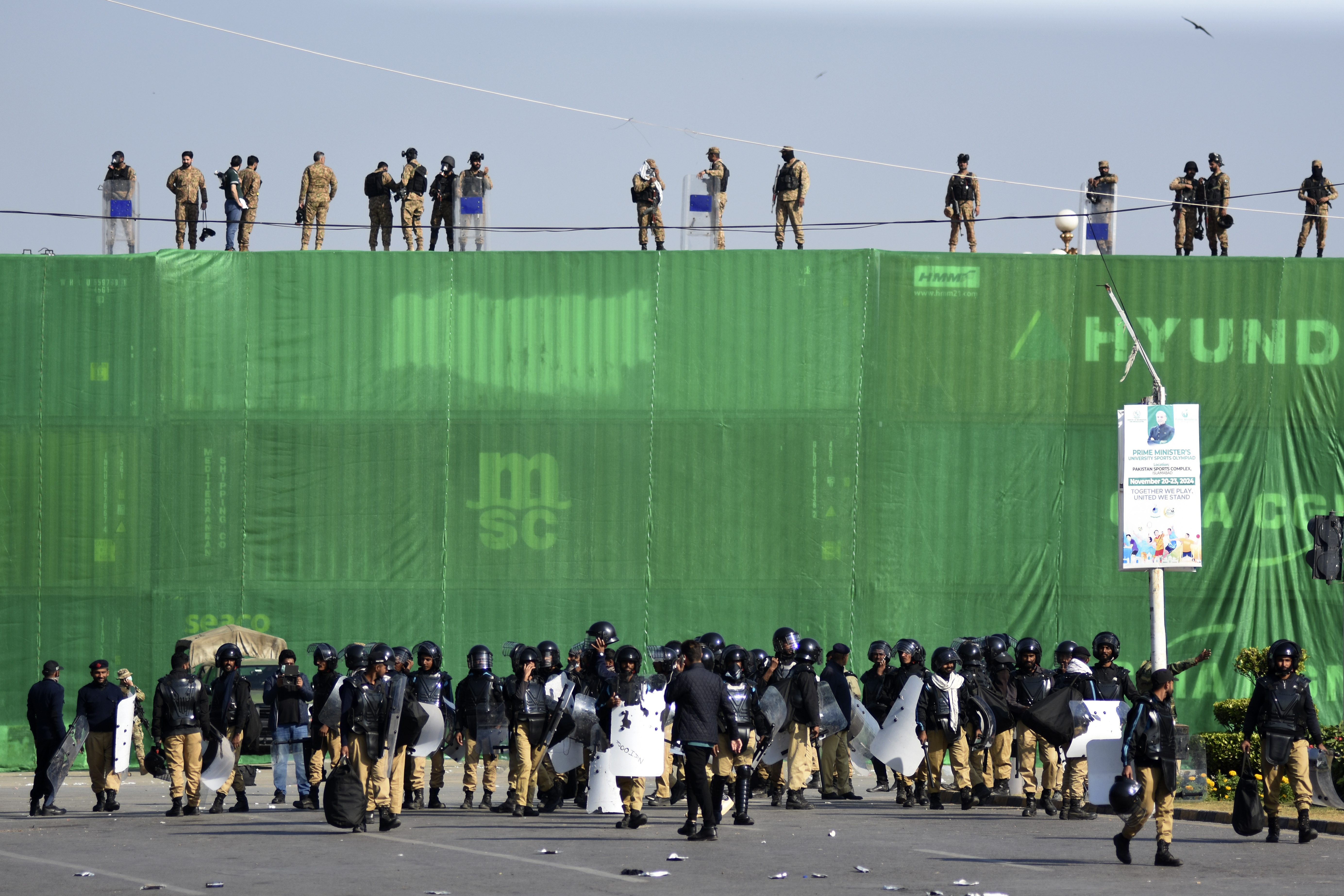 Pakistan's army troops and police officers take positions at D-Chowk square close to Red Zone, which is an area that houses key government buildings, ahead of a protest by supporters of imprisoned former premier Imran Khan's Pakistan Tehreek-e-Insaf party, in Islamabad, Pakistan, Tuesday, Nov. 26, 2024. (AP Photo/W.K. Yousufzai)
