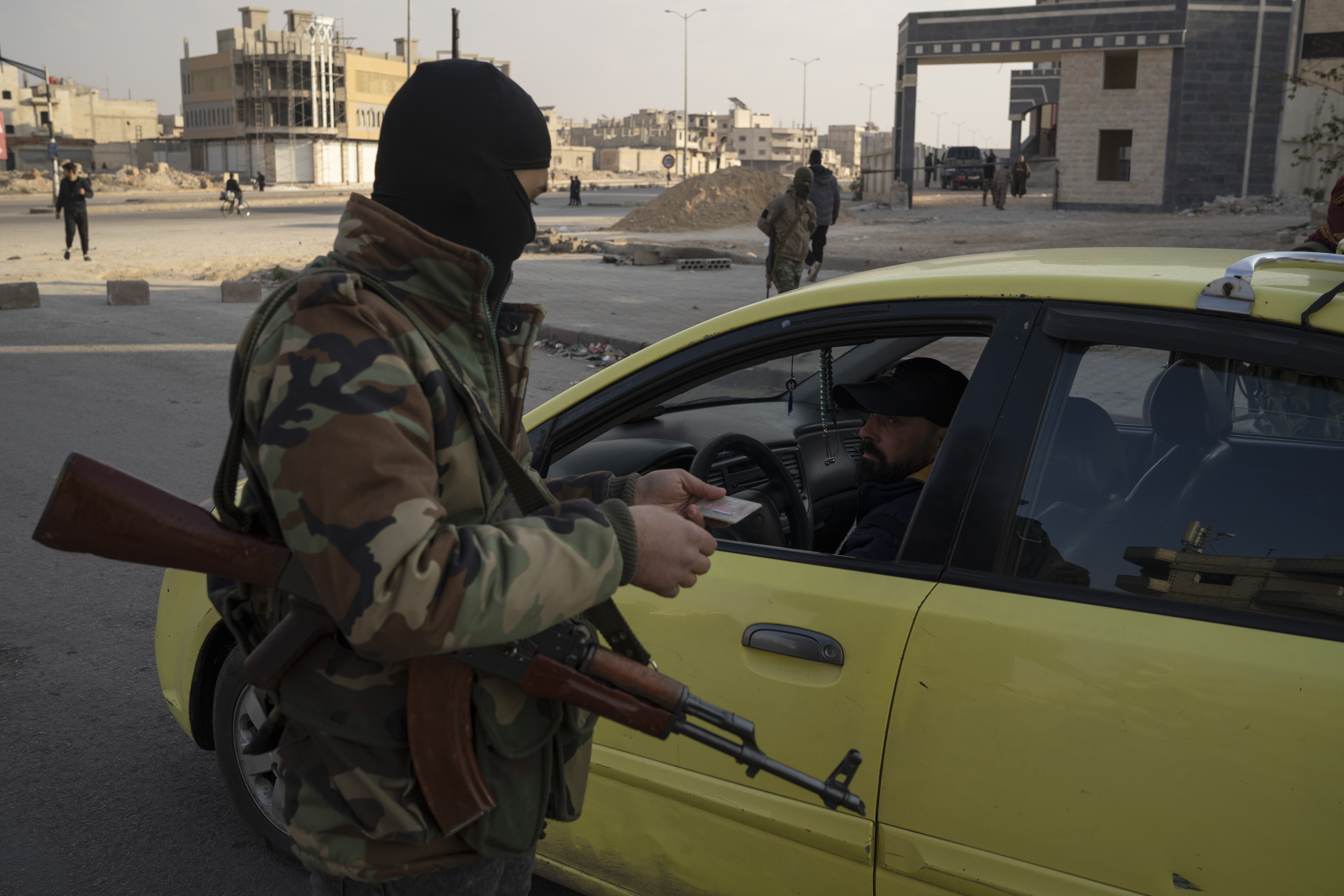 A member of the security forces of the newly formed Syrian government patrols an area near to a security checkpoint in Homs, Syria, Thursday, Dec. 26