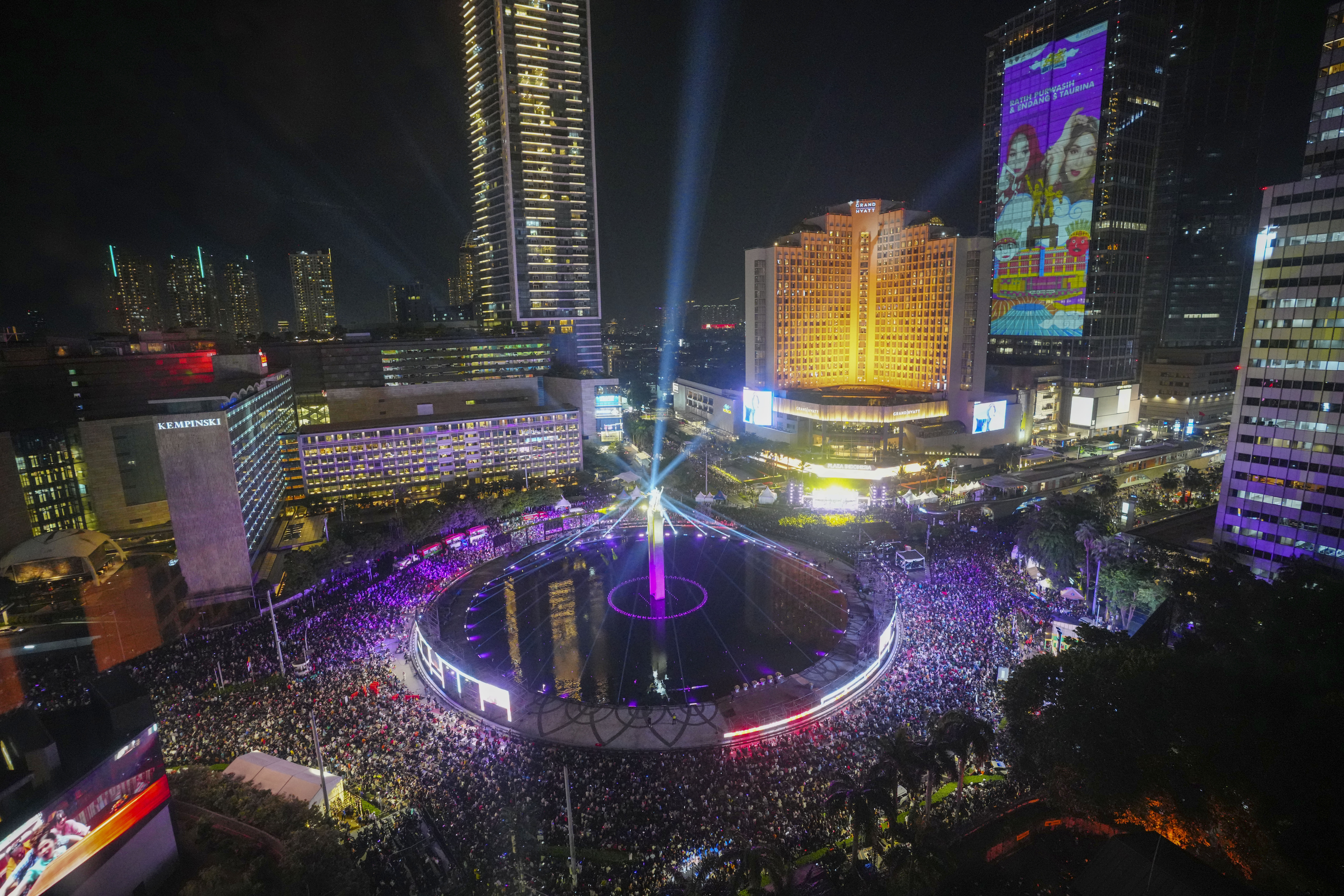 People gather in the main business district on New Year's Eve in Jakarta, Indonesia, Tuesday, Dec. 31