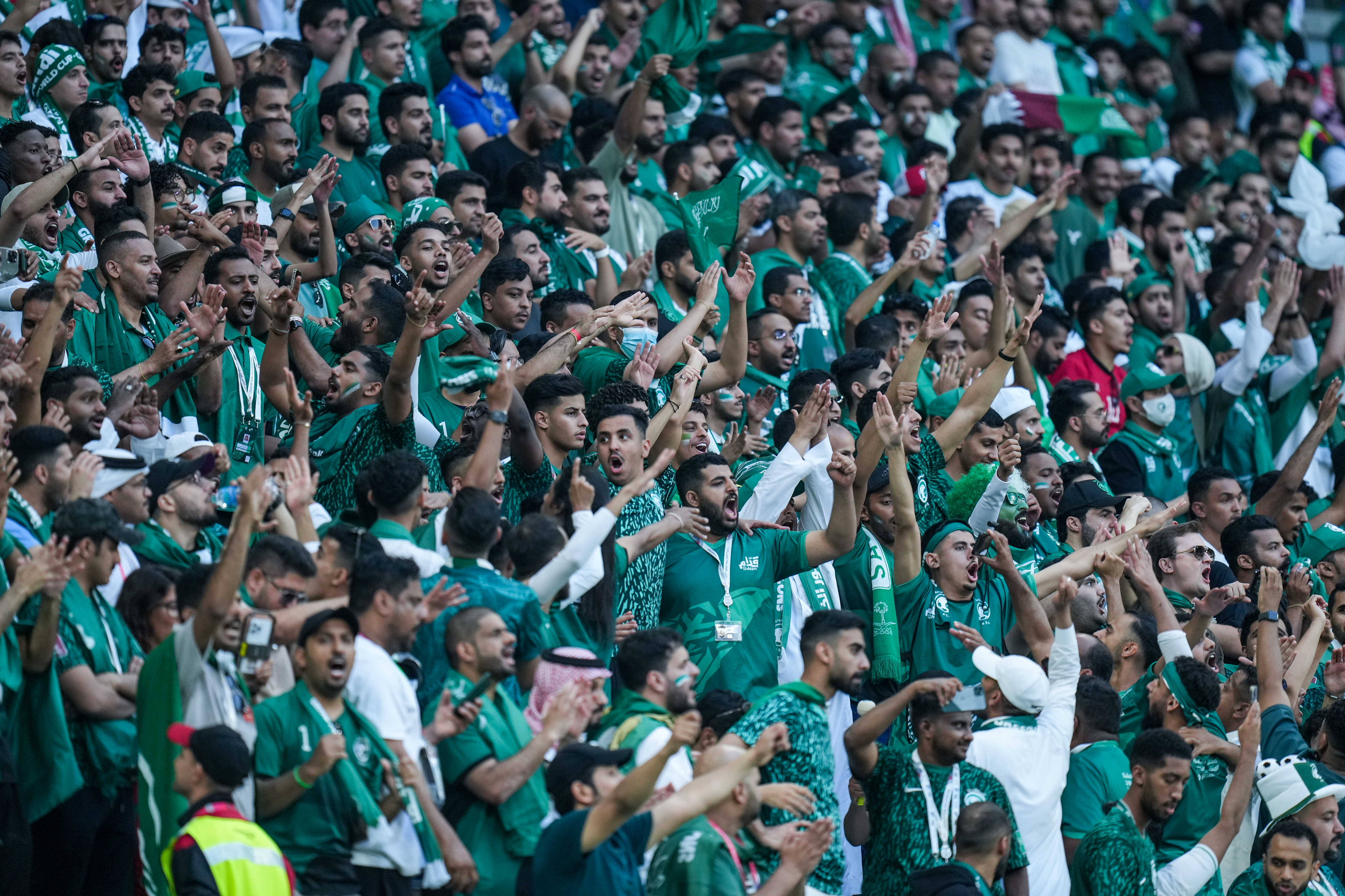 Saudi Arabia football fans cheering at game.