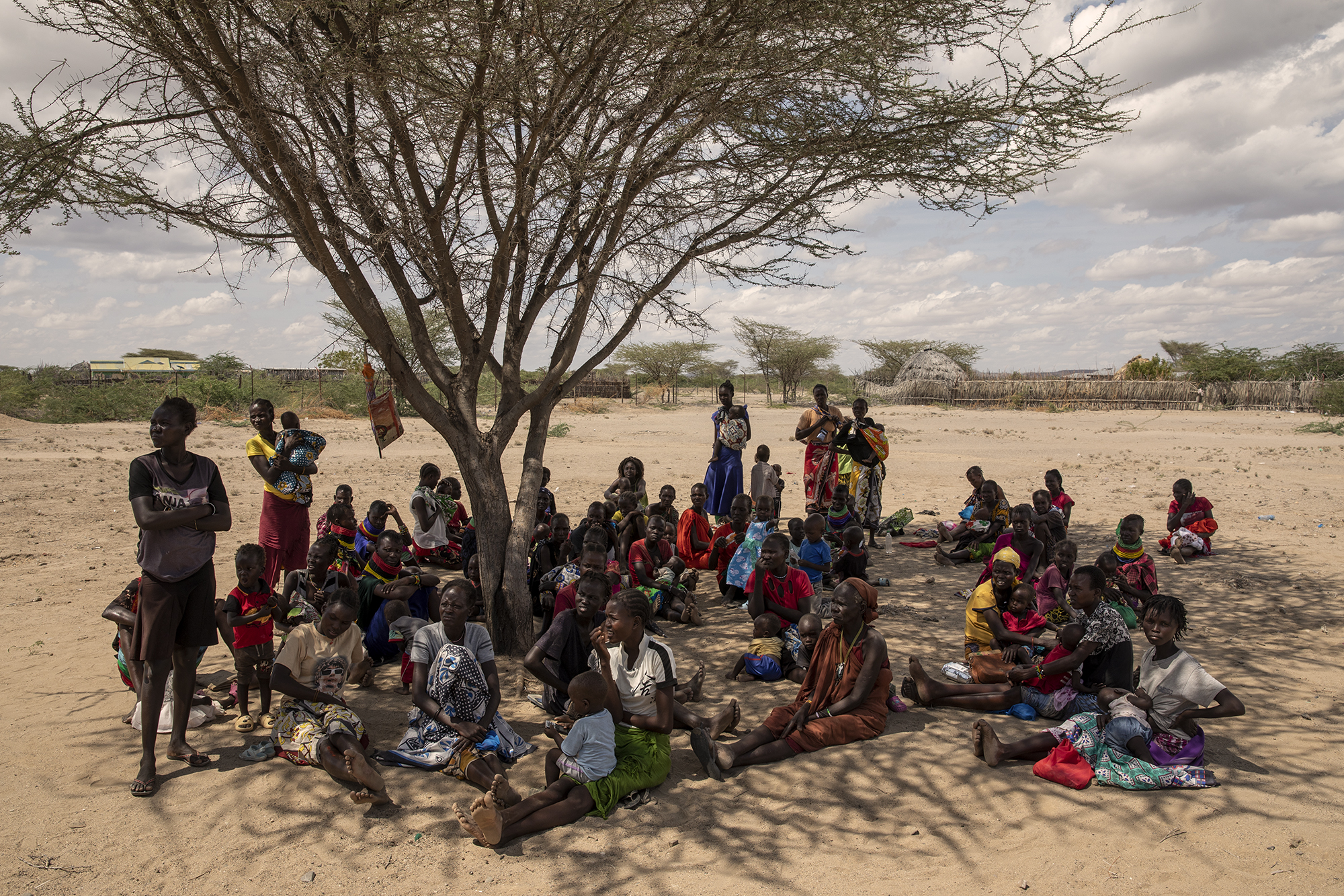 Women and children wait their turn outside the Kalokol Gok Health Centre, located in Turkana County, northwest Kenya on October 16, 2024. The Kalokol Gok Health Centr welcomes women and children from the surrounding villages to provide them with medicines, food supplements and to monitor their health conditions, which are put at risk by the severe drought that is affecting the country. [Alessio Paduano/Al Jazeera]
