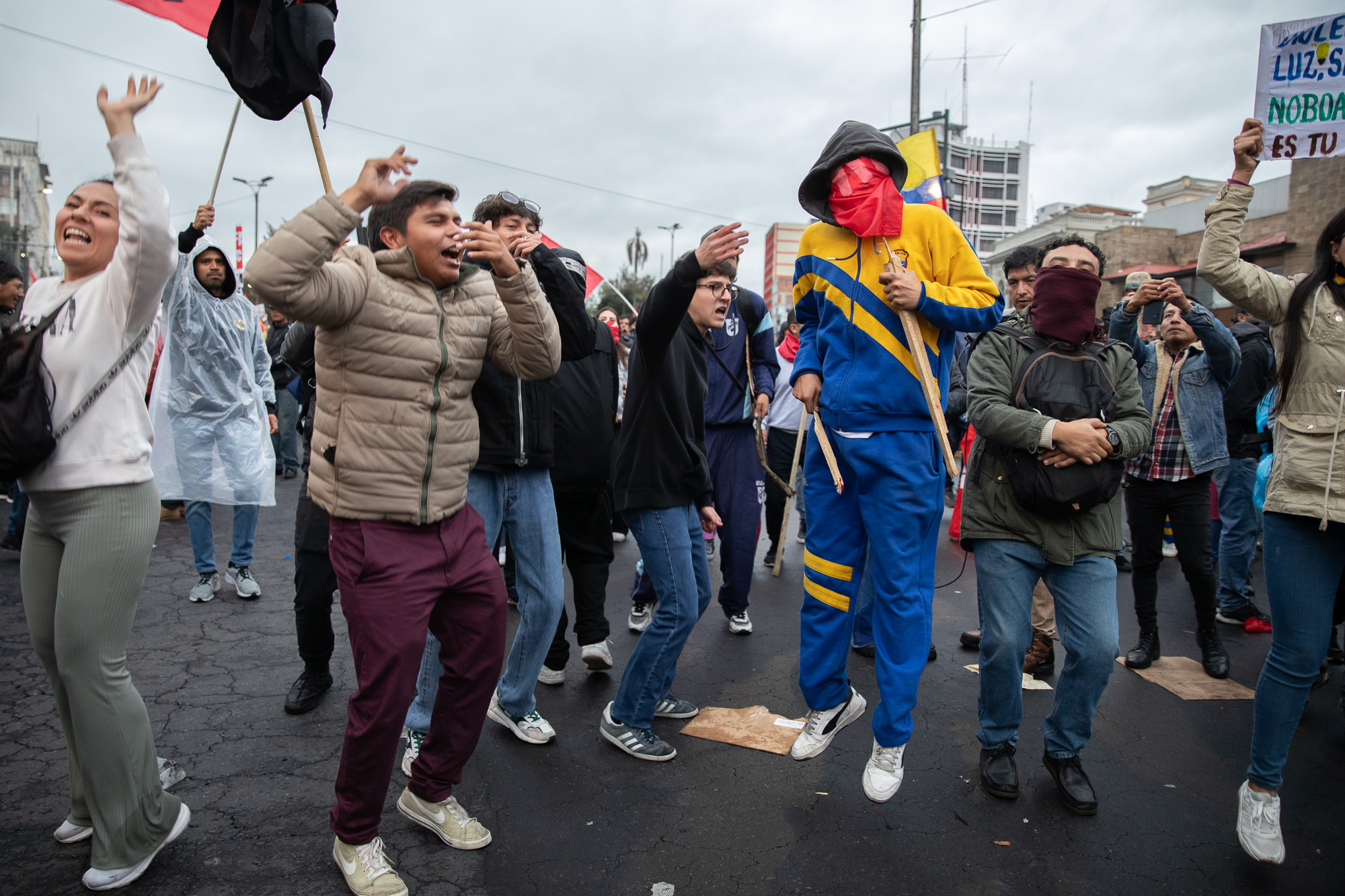 Protesters jump, shout and wave flags and signs in Quito.