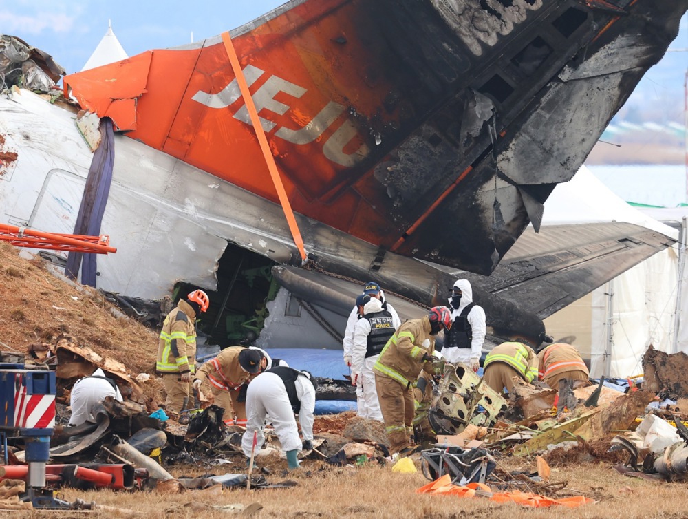 epaselect epa11804616 Forensic experts, police investigators and firefighters work at the site of a deadly plane crash at Muan International Airport, in Muan, southwestern South Korea, 04 January 2025. A Jeju Air passenger plane crashed into a localizer, a navigation system that assists in aircraft landings, at the airport on 29 December 2024, killing all but two of the 181 people onboard. EPA-EFE/YONHAP
