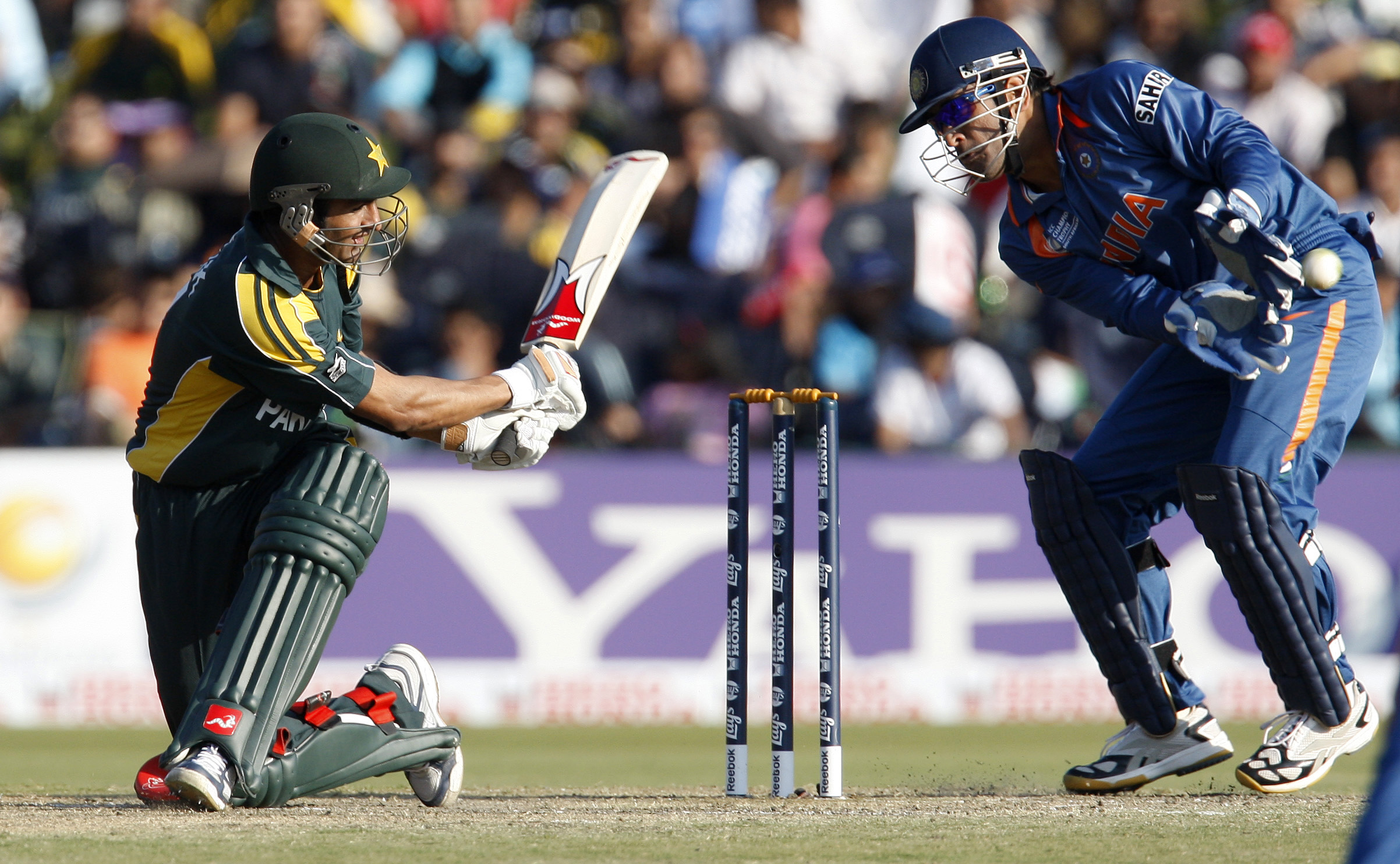 Pakistan's Shoaib Malik (L) plays a shot beside India's MS Dhoni during their ICC Champions Trophy cricket match in Pretoria September 26, 2009. REUTERS/Mike Hutchings (SOUTH AFRICA SPORT CRICKET)