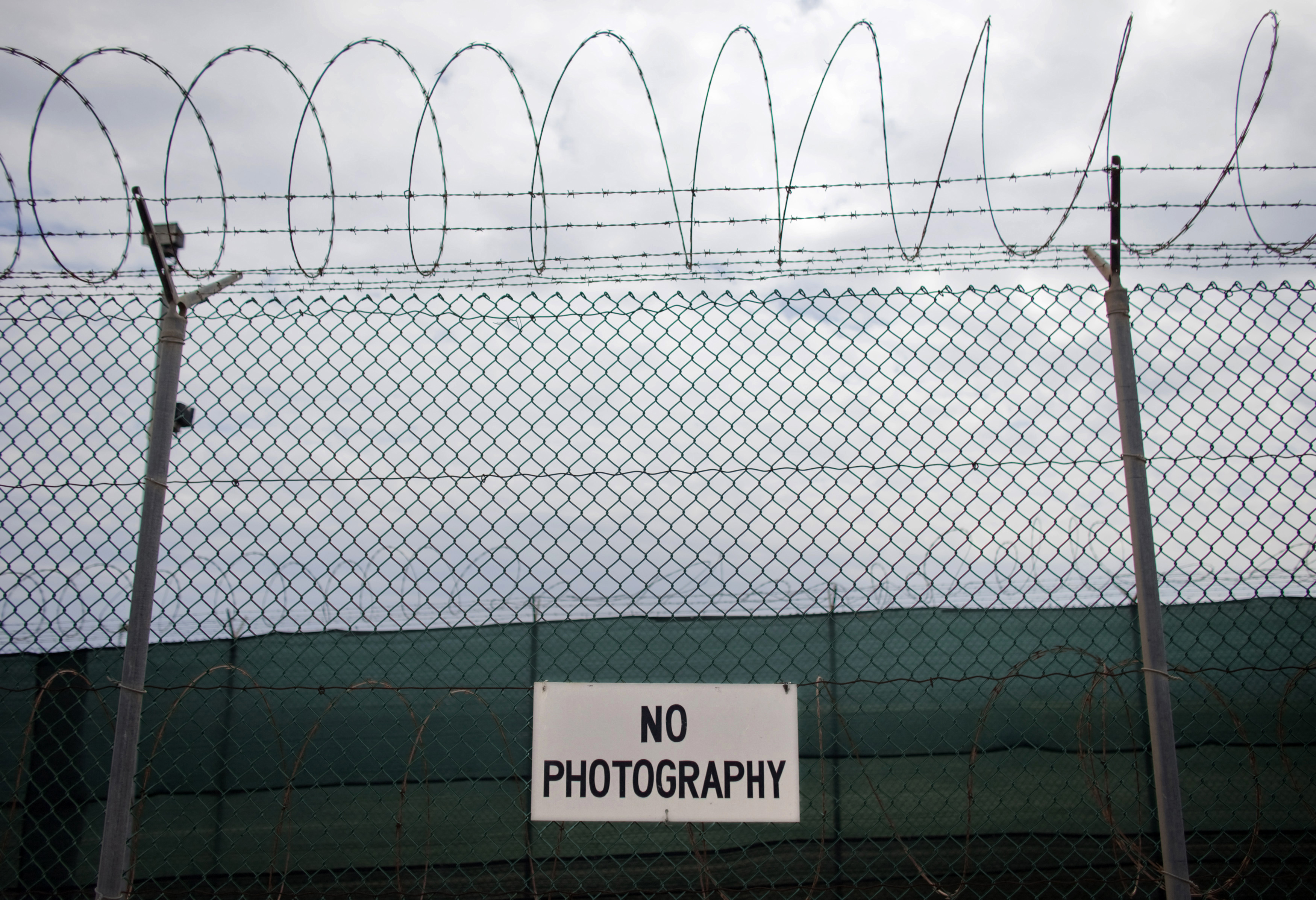 No photography signs are posted on the fence surrounding Camp Delta at the U.S. Naval Base at Guantanamo Bay, March 6, 2013. The facility is operated by the Joint Task Force Guantanamo and holds prisoners who have been captured in the war in Afghanistan and elsewhere since the September 11, 2001 attacks. Picture taken March 6, 2013. REUTERS/Bob Strong (CUBA - Tags: POLITICS MILITARY CRIME LAW)