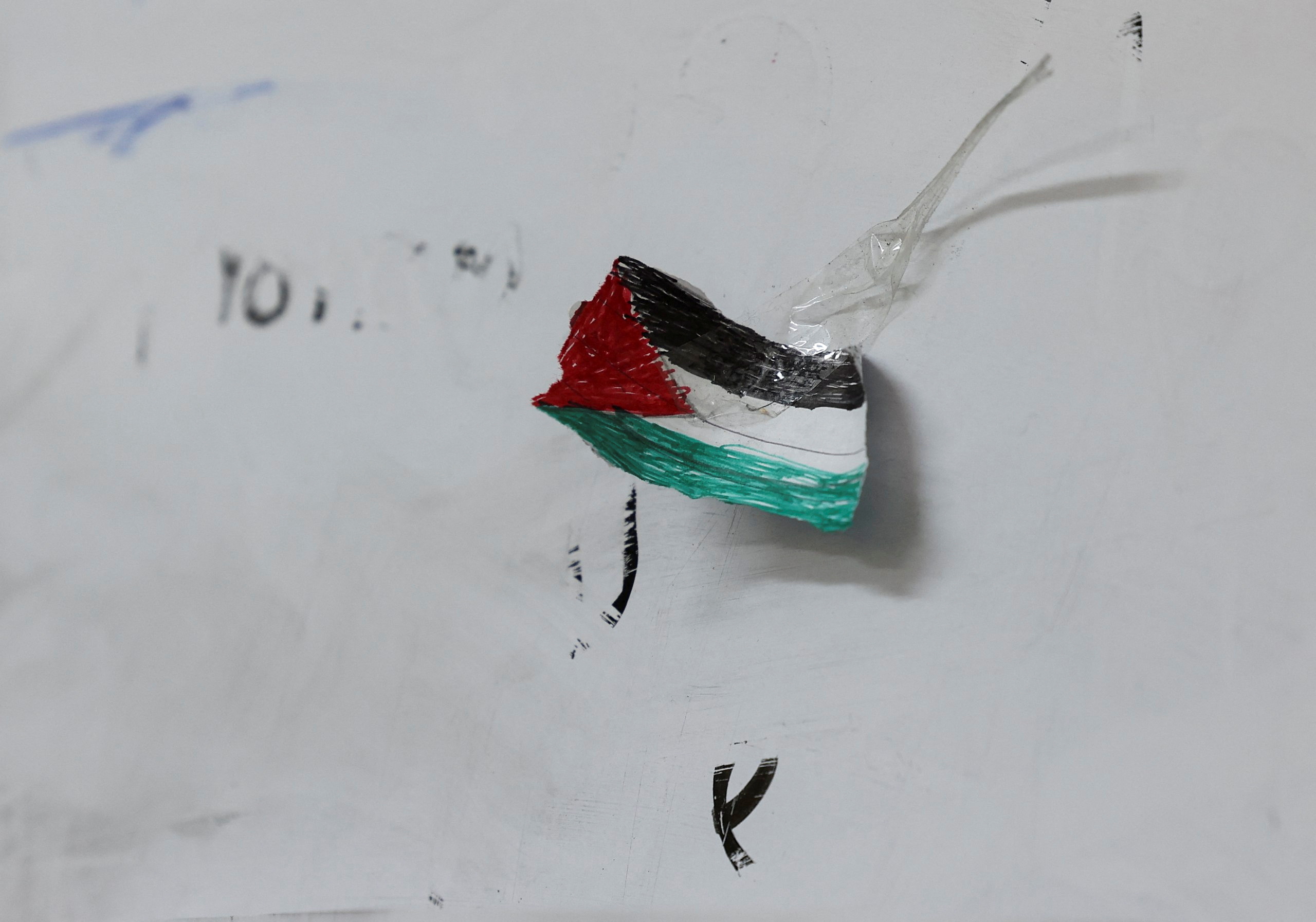 A drawing of a Palestinian flag hangs on a wall.