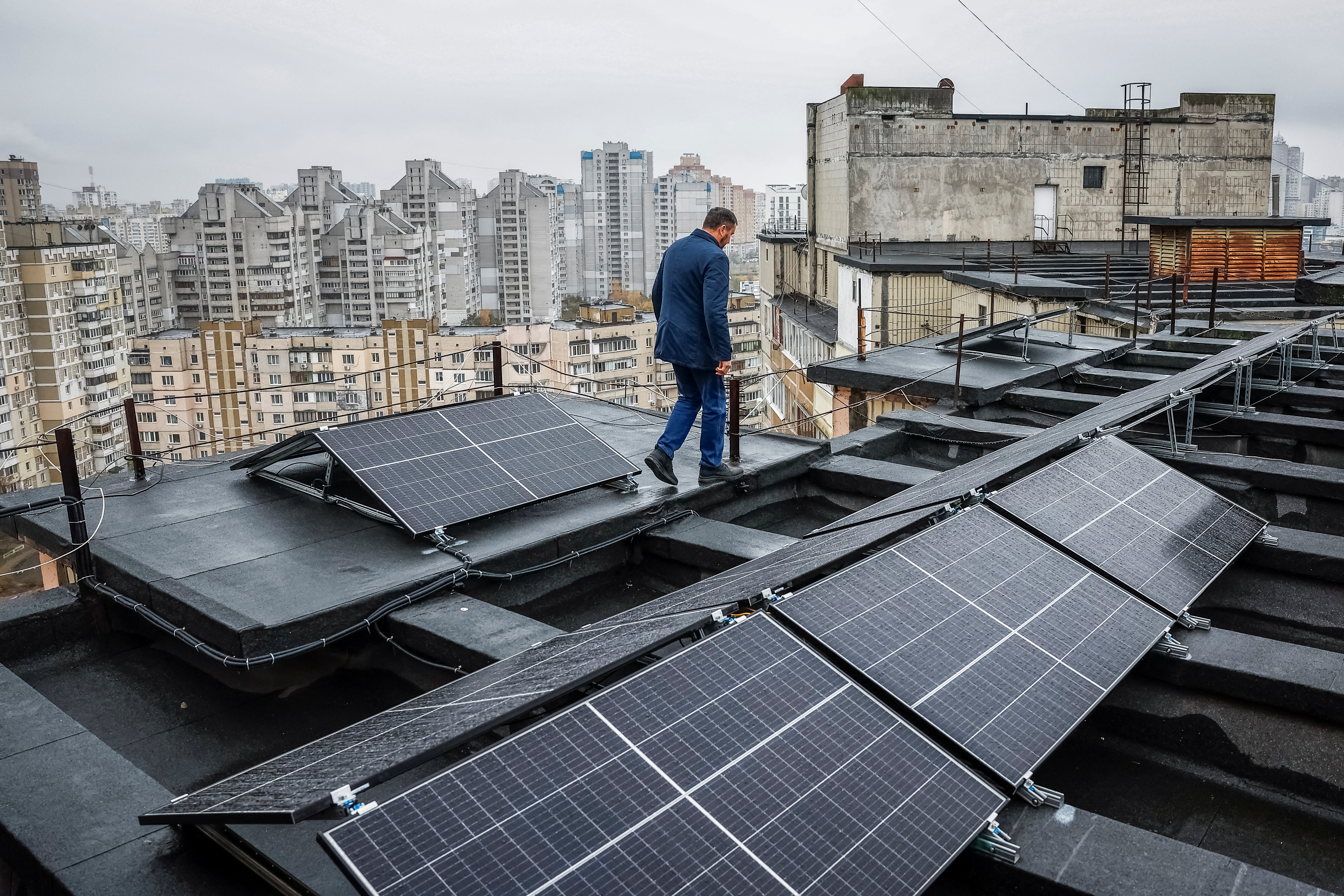 Valerii Pyndyk, head of a housing association board, appears on the roof of an apartment building, where solar panels were installed in Kyiv, Ukraine