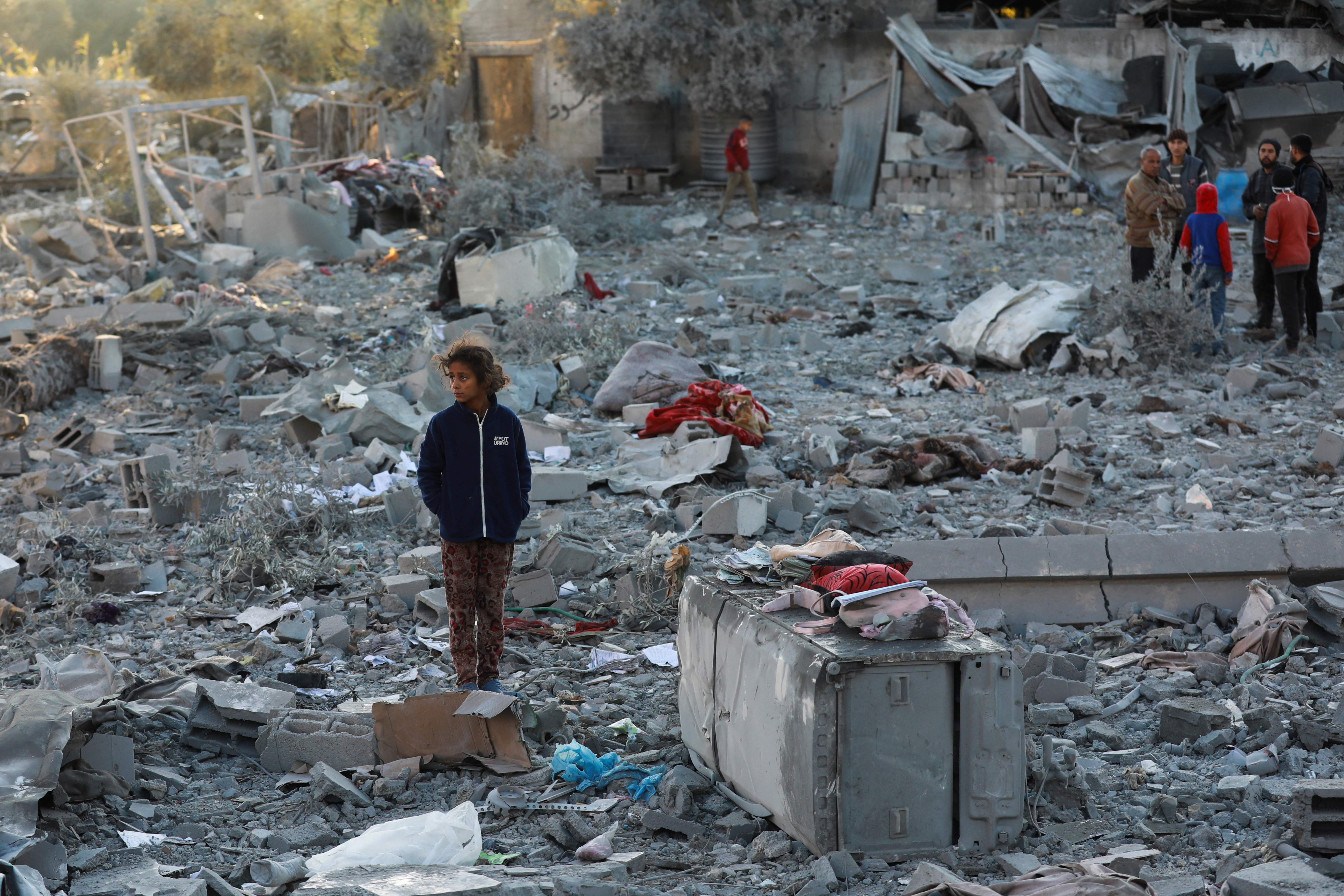A Palestinian girl stands near the site of an Israeli strike on a house.