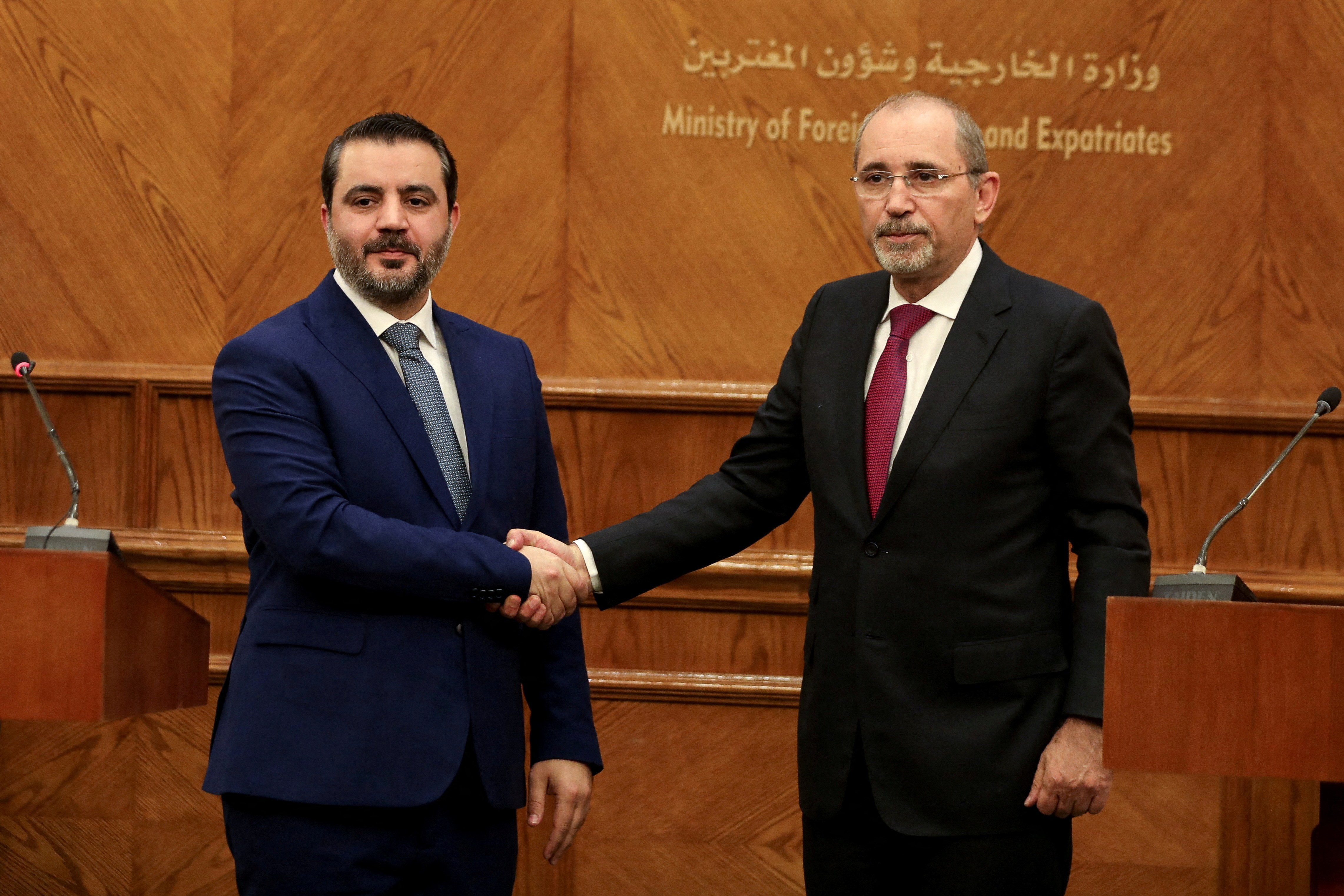 Syrian Foreign Minister Asaad Hassan al-Shibani and Jordanian Foreign Minister Ayman Safadi shake hands during a press conference as they meet in Amman, Jordan January 7, 2025. REUTERS/Alaa Al Sukhni