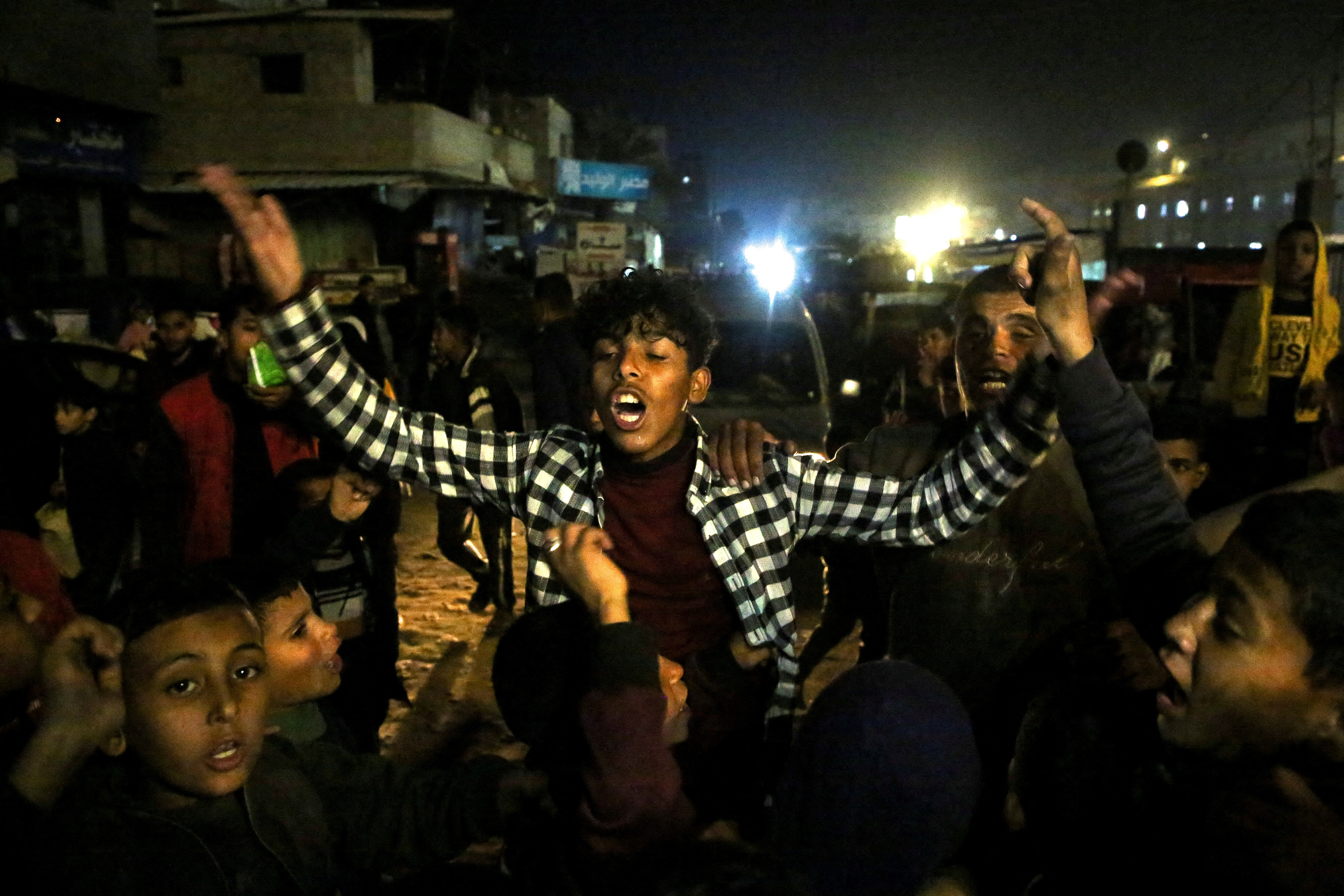Palestinians react as they wait for news of a ceasefire deal with Israel, in Khan Younis