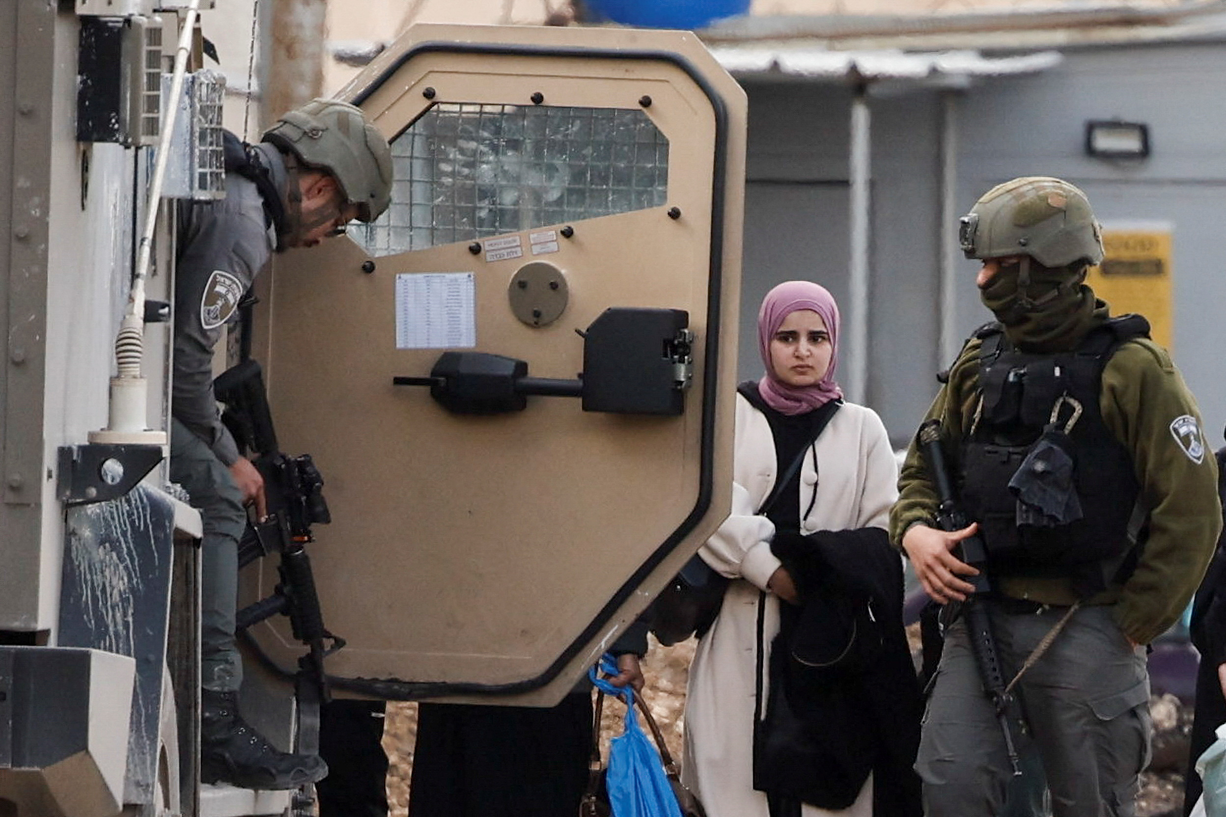 A Palestinian girl stands during an Israeli raid