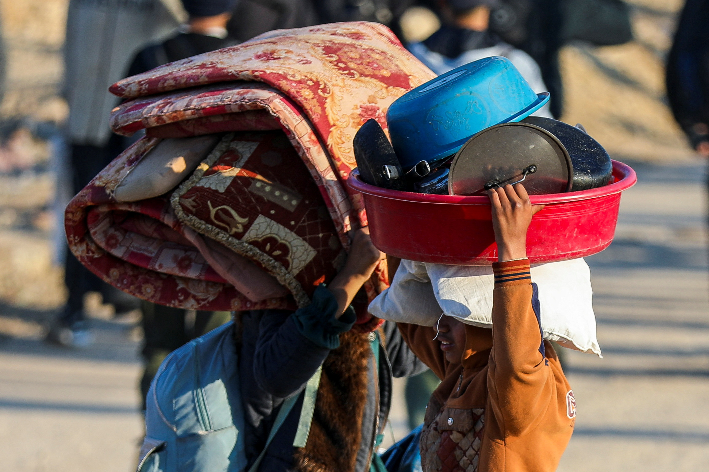 Palestinians walk back to their homes in northern Gaza
