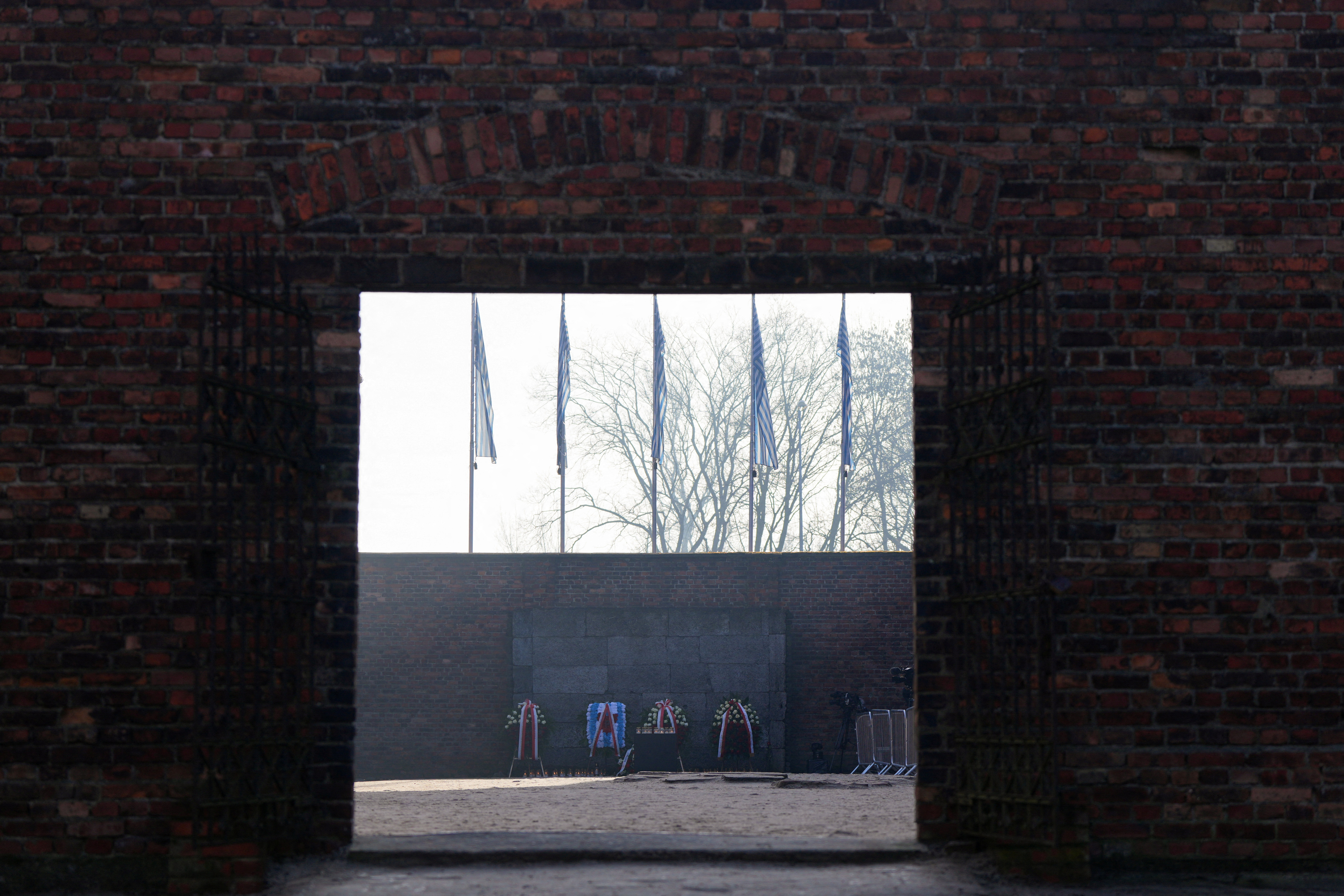 Wreaths stand in front of the Death Wall of the Auschwitz-Birkenau camp.