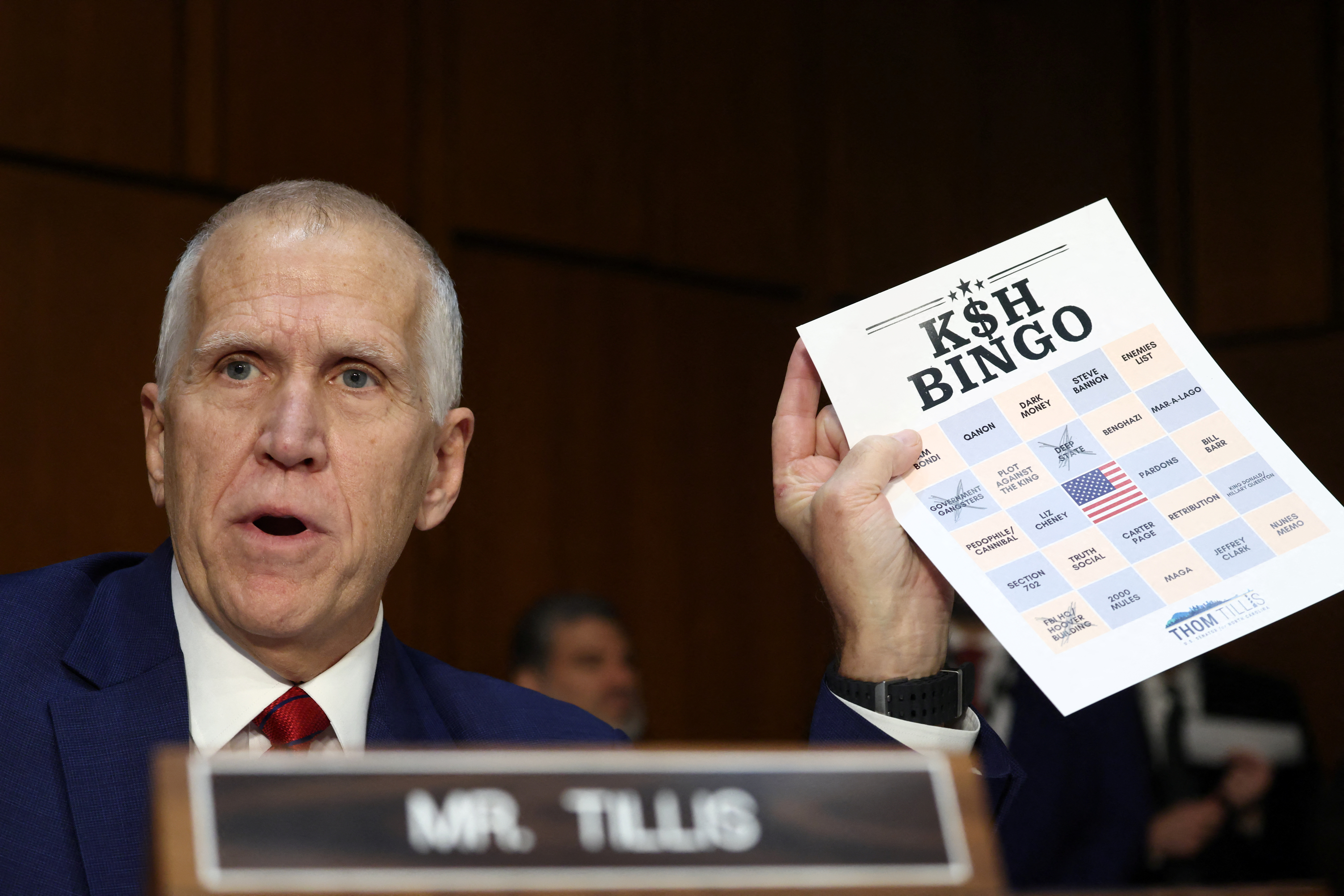 Thom Tillis holds up a sheet labeled "K$H Bingo"