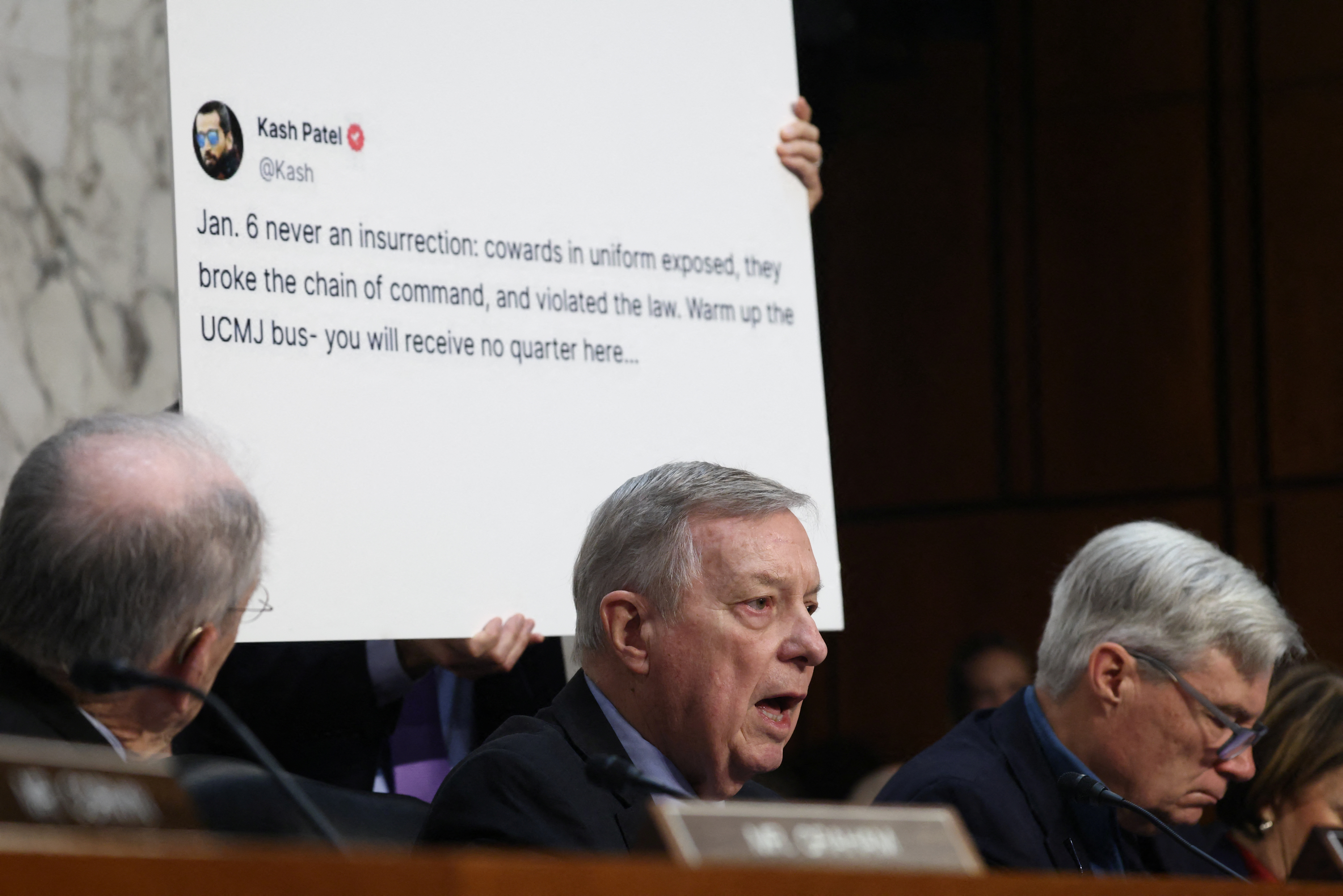Dick Durbin speaks next to an image of Kash Patel's tweets.