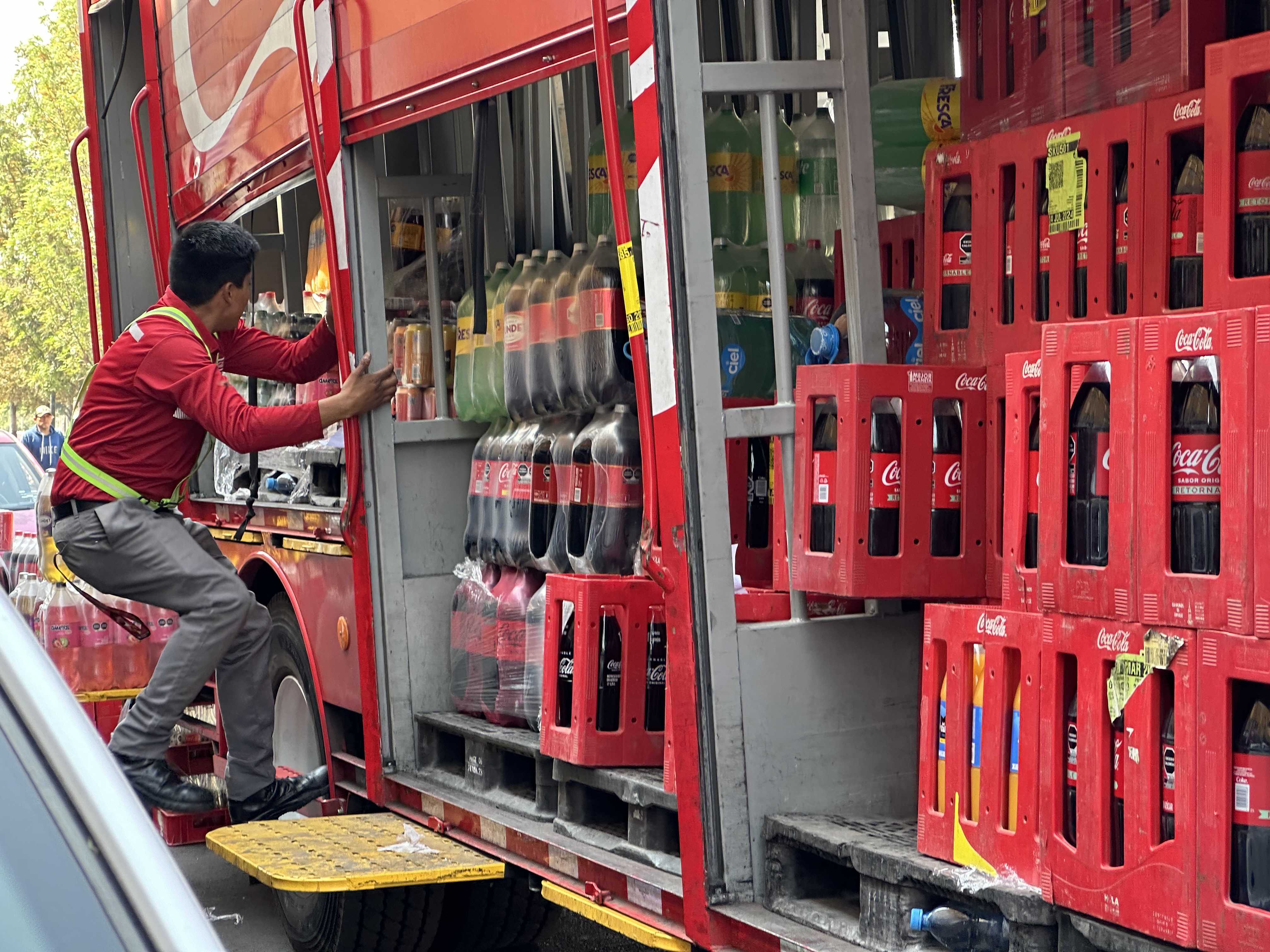 A delivery truck worker unloads pallets of Coca-Cola