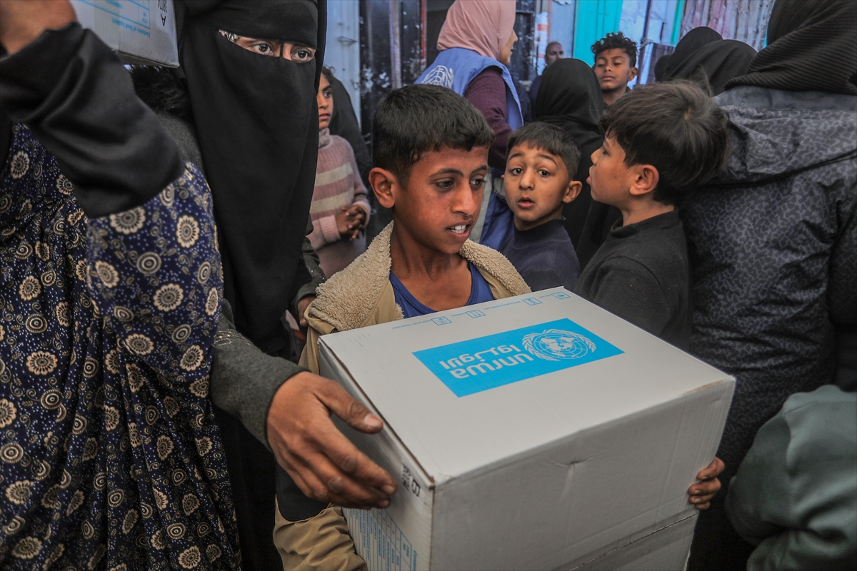 A child holds a box that says UNRWA