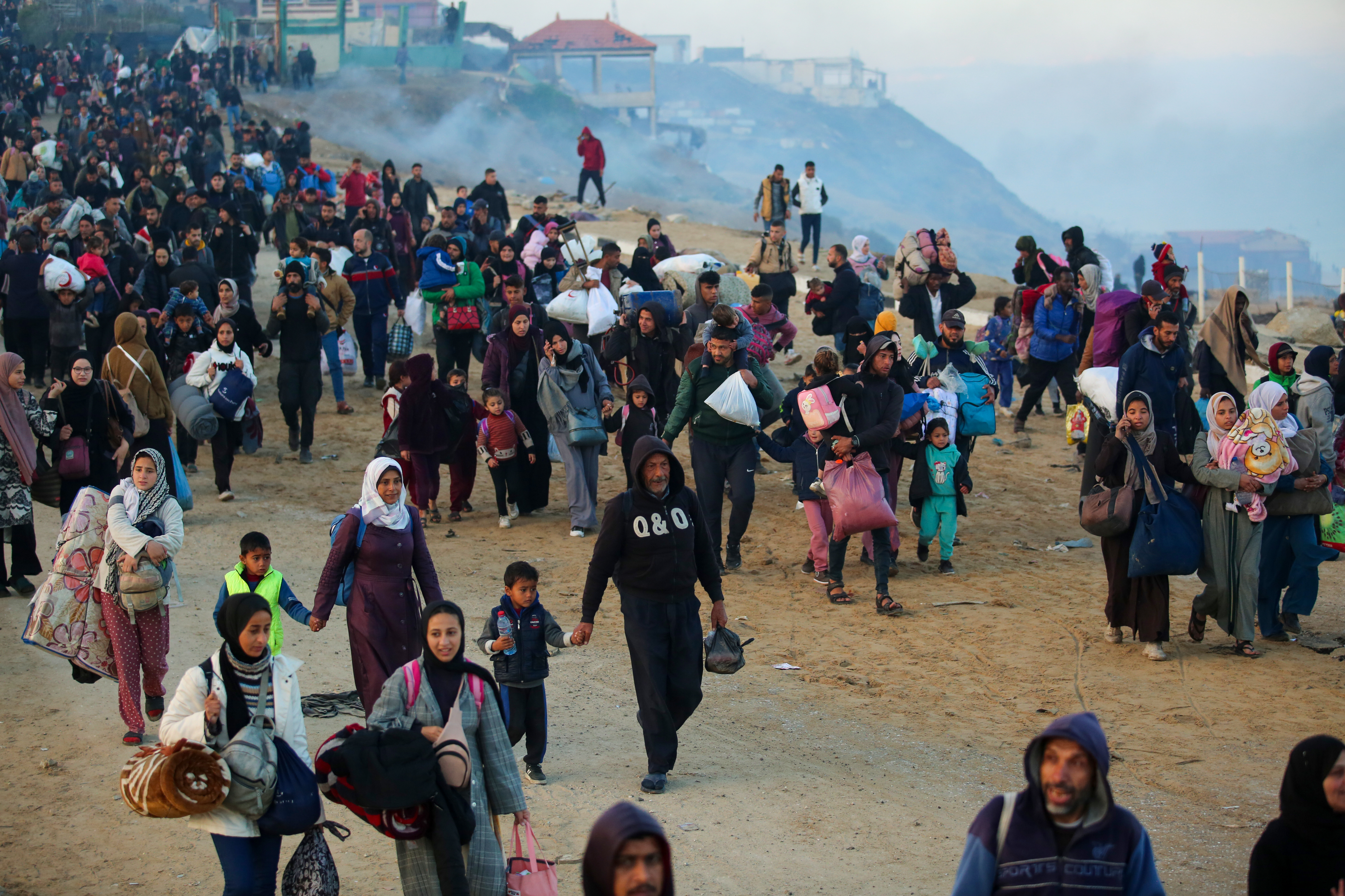 Palestinians walk back to their homes in northern Gaza