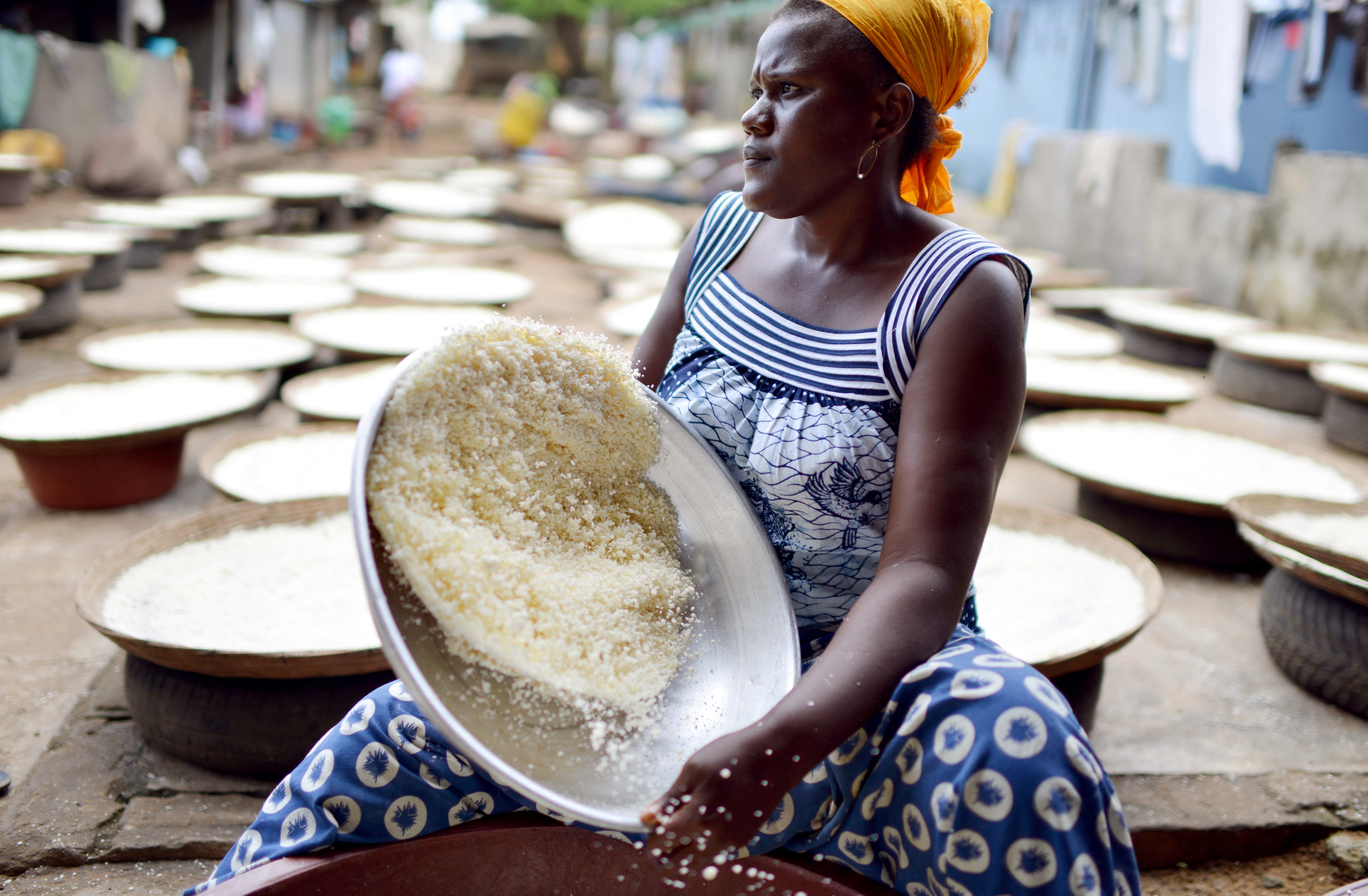 A woman sieves manioc flour.