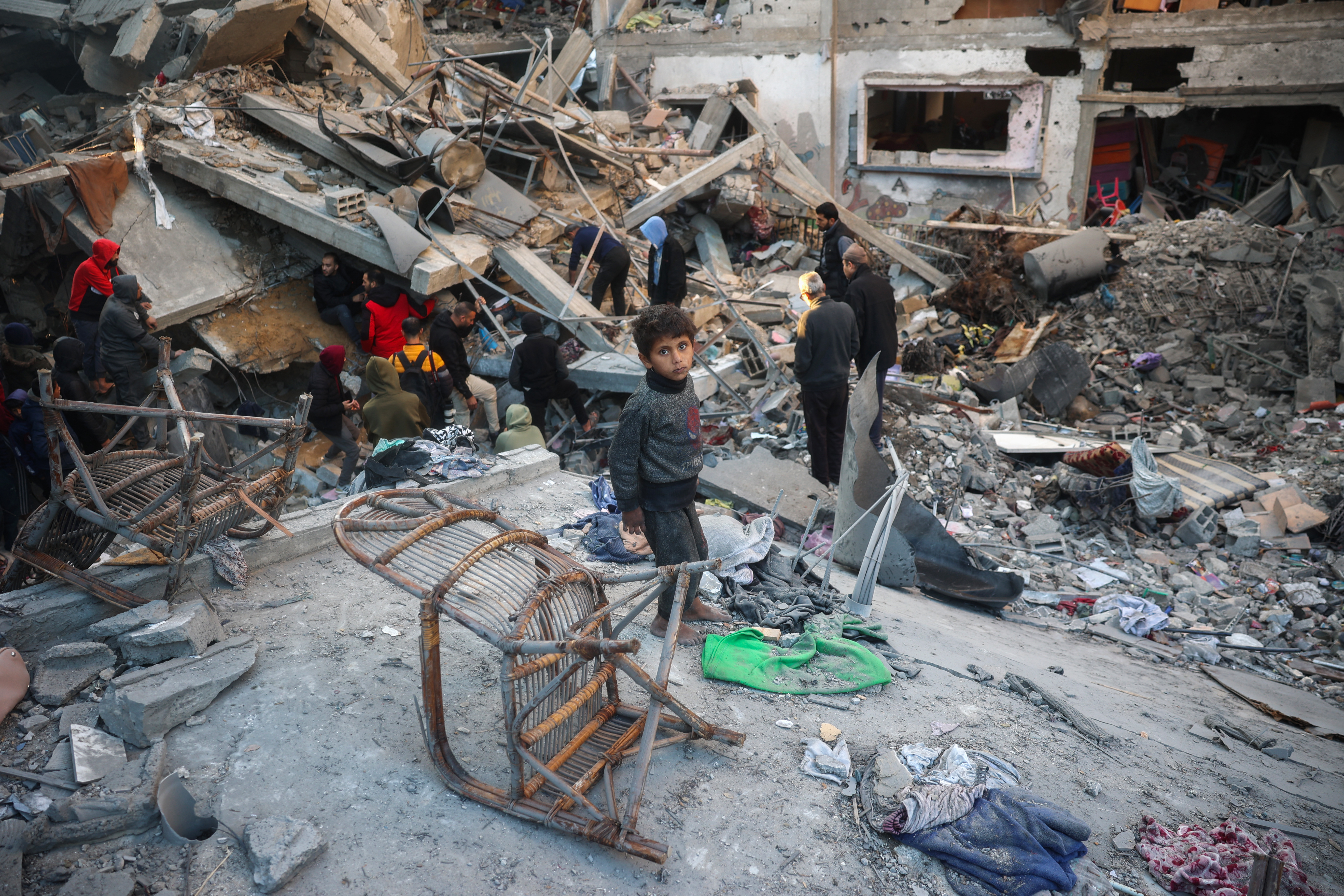 People search the rubble of a building destroyed in an Israeli strike on the Bureij camp for Palestinian refugees in the central Gaza Strip on January 8, 2025 as the war between Israel and the Palestinian Hamas movement continues. (Photo by Eyad BABA / AFP)