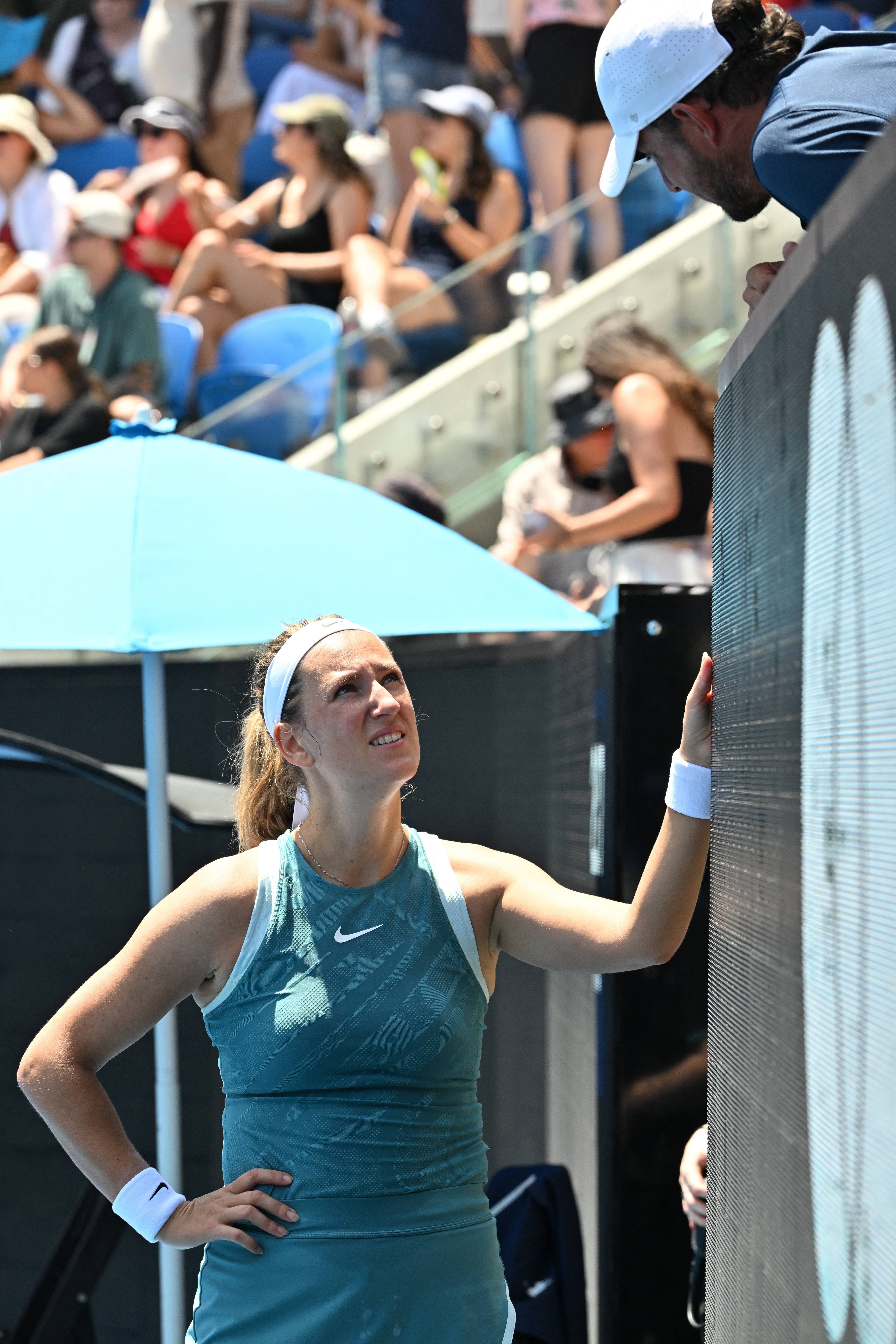 Belarus' Victoria Azarenka consults with her coach Maxime Tchoutakian at the court-side coaching pod while playing against Italy's Lucia Bronzetti during their women's singles match on day two of the Australian Open tennis tournament in Melbourne on January 13, 2025. (Photo by Paul Crock / AFP) / -- IMAGE RESTRICTED TO EDITORIAL USE - STRICTLY NO COMMERCIAL USE --