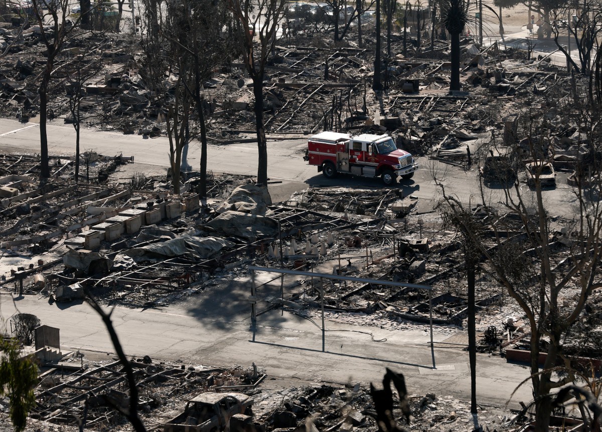 A fire crew drives through a mobile home park that was destroyed by the Palisades Fire