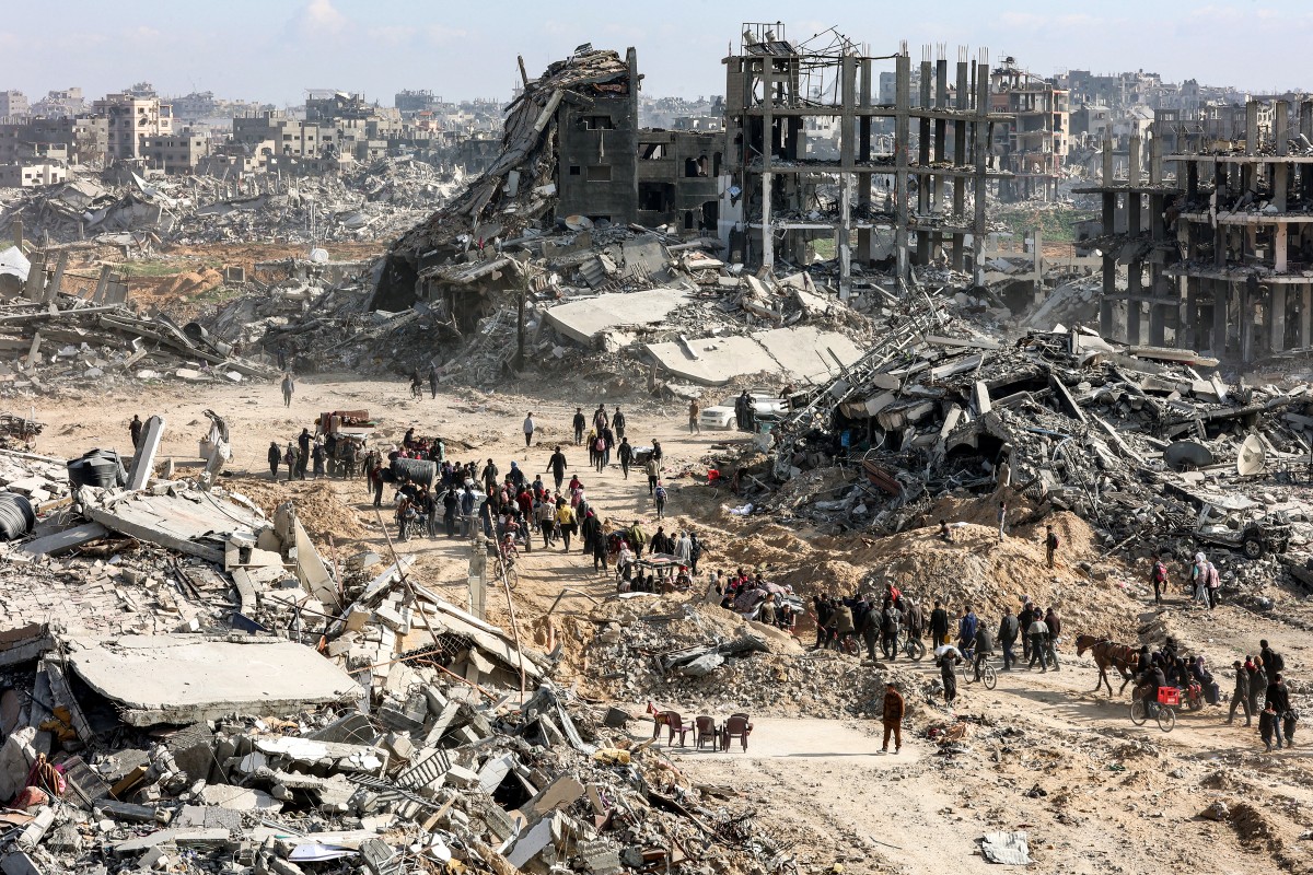 People walk past rubble in Gaza