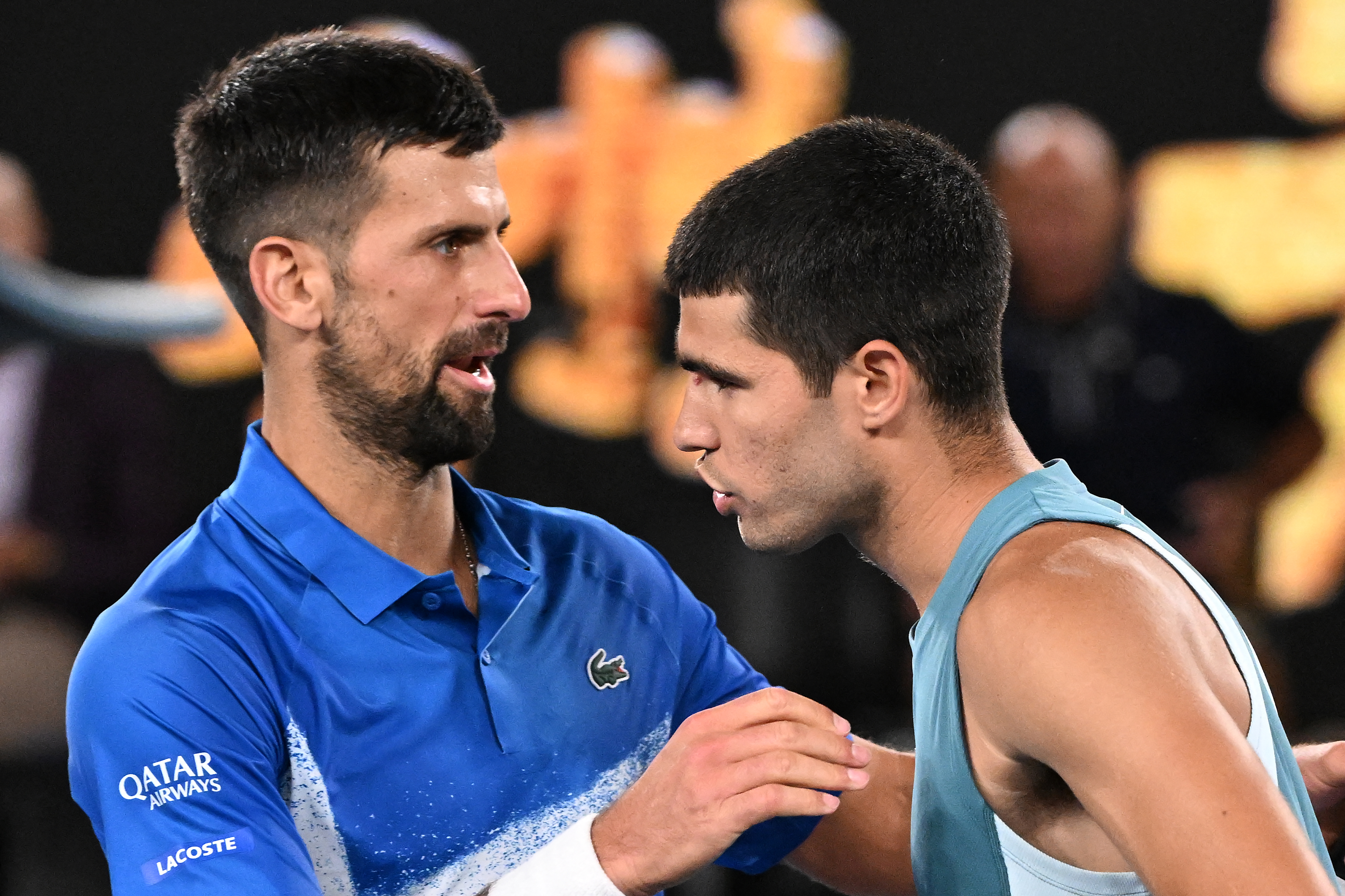 Serbia's Novak Djokovic (L) embraces Spain's Carlos Alcaraz after their men's singles quarterfinal match on day ten of the Australian Open tennis tournament in Melbourne on January 22, 2025. (Photo by WILLIAM WEST / AFP) / -- IMAGE RESTRICTED TO EDITORIAL USE - STRICTLY NO COMMERCIAL USE --