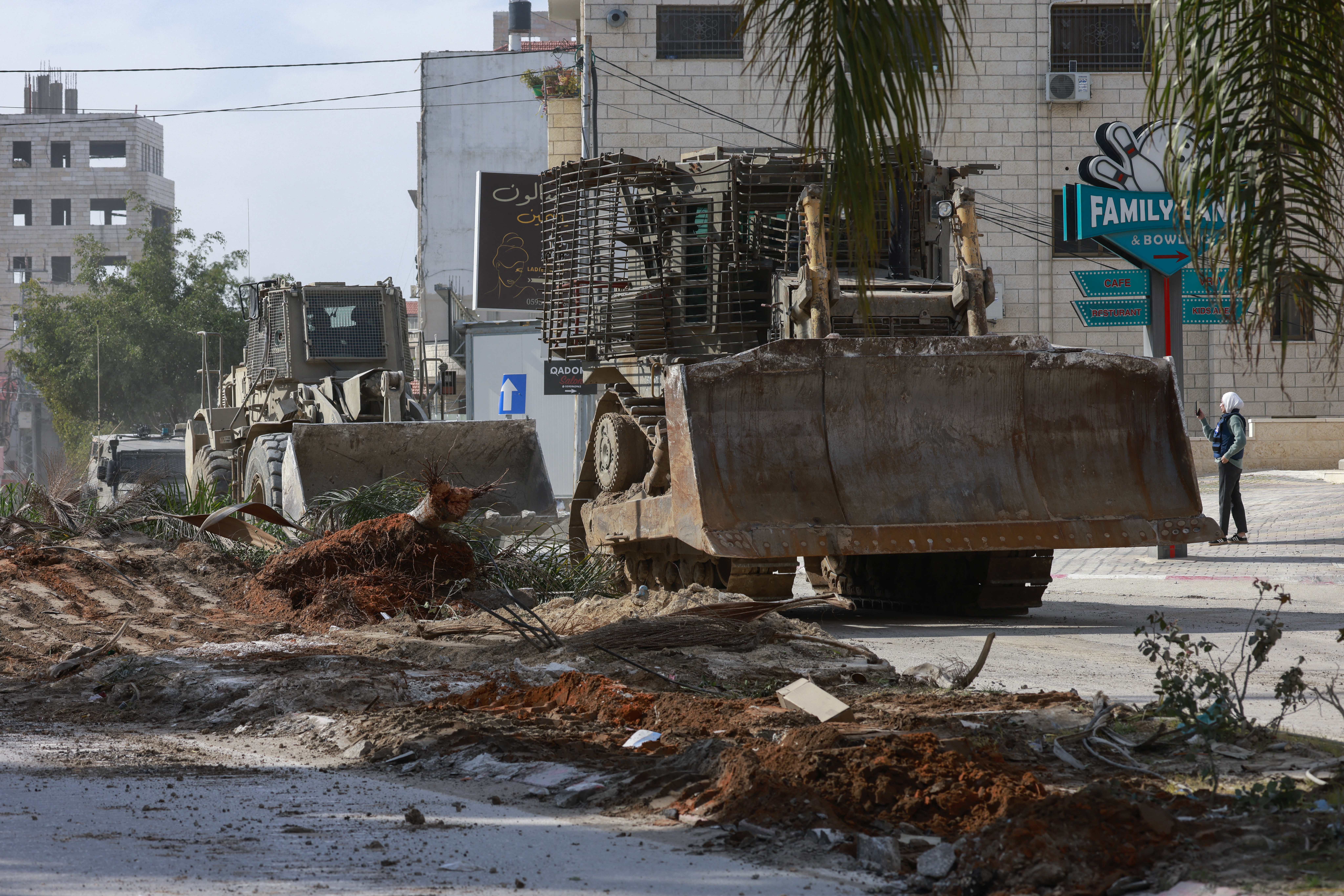 Israeli army bulldozers drive in a military convoy during a raid in Tulkarem in the Israel-occupied West Bank on January 28, 2025. (Photo by Jaafar ASHTIYEH / AFP)