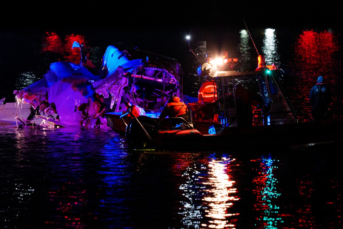 An emergency response team with Washington, DC Fire and EMS make their way to airplane wreckage in the Potomac River