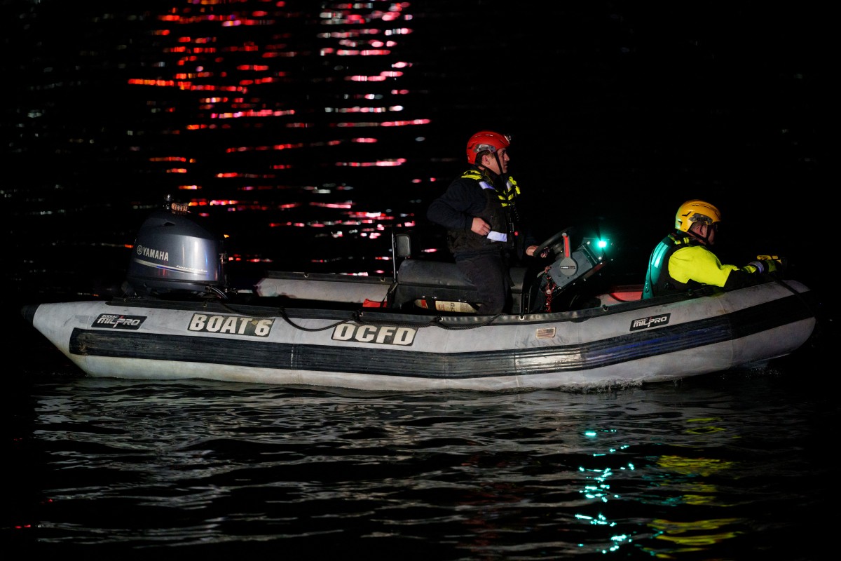 An emergency response team with Washington, DC Fire and EMS make their way to airplane wreckage in the Potomac River