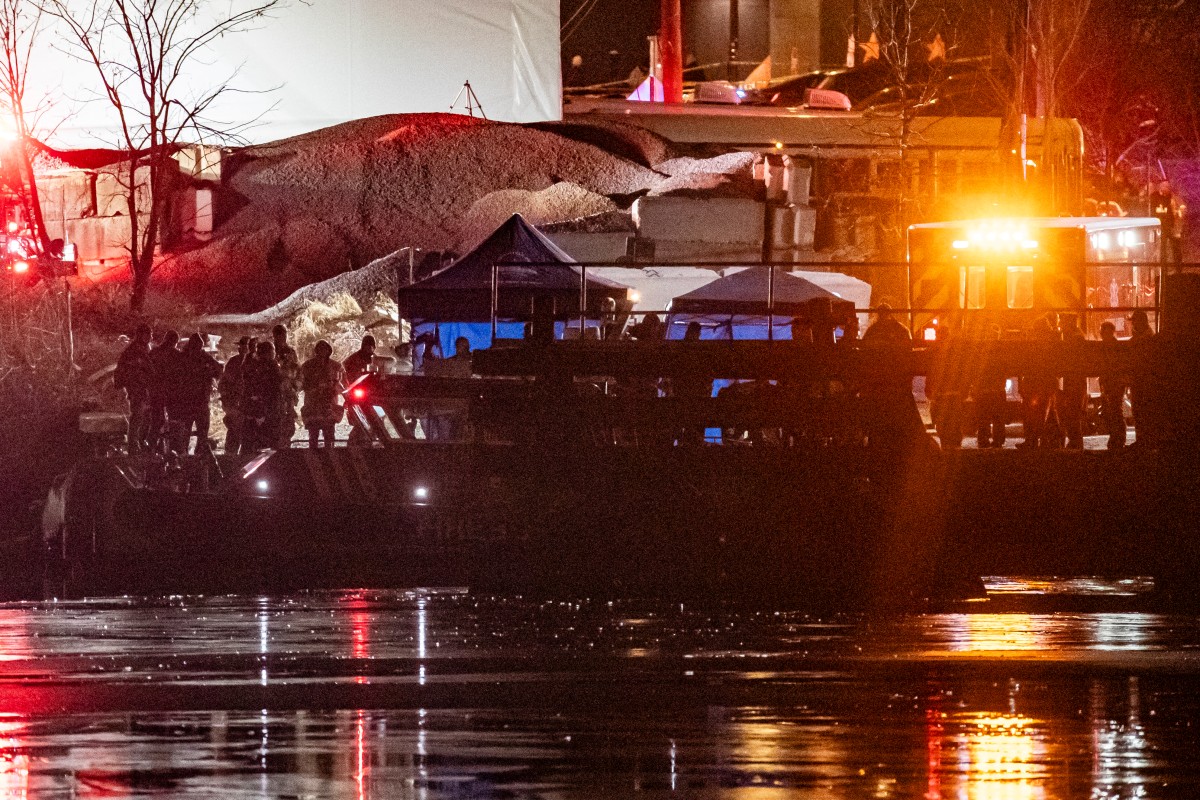 An emergency response team with Washington, DC Fire and EMS make their way to airplane wreckage in the Potomac River