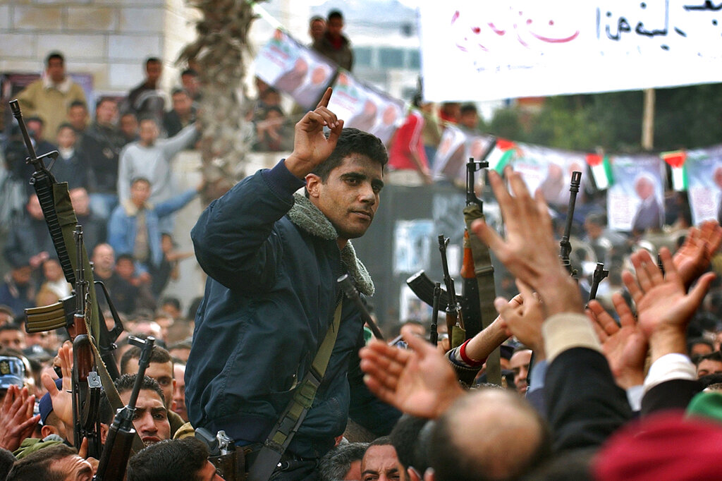 FILE – In this Dec. 30, 2004 file photo, Zakaria Zubeidi, then leader in the Al Aqsa Martyrs Brigade in the West Bank, is carried by supporters during a presidential elections campaign rally in support of Mahmoud Abbas, in the West Bank town of Jenin. In May, as the Gaza war raged and tensions surged across the Middle East, Instagram briefly banned the hashtag #AlAqsa, a reference to the Al-Aqsa Mosque in Jerusalem's Old City, a flash point in the conflict. Facebook, which owns Instagram, later apologized, explaining its algorithms had mistaken the third-holiest site in Islam for the militant group Al-Aqsa Martyrs Brigade, an armed offshoot of the secular Fatah party. (AP Photo/Nasser Nasser, File)