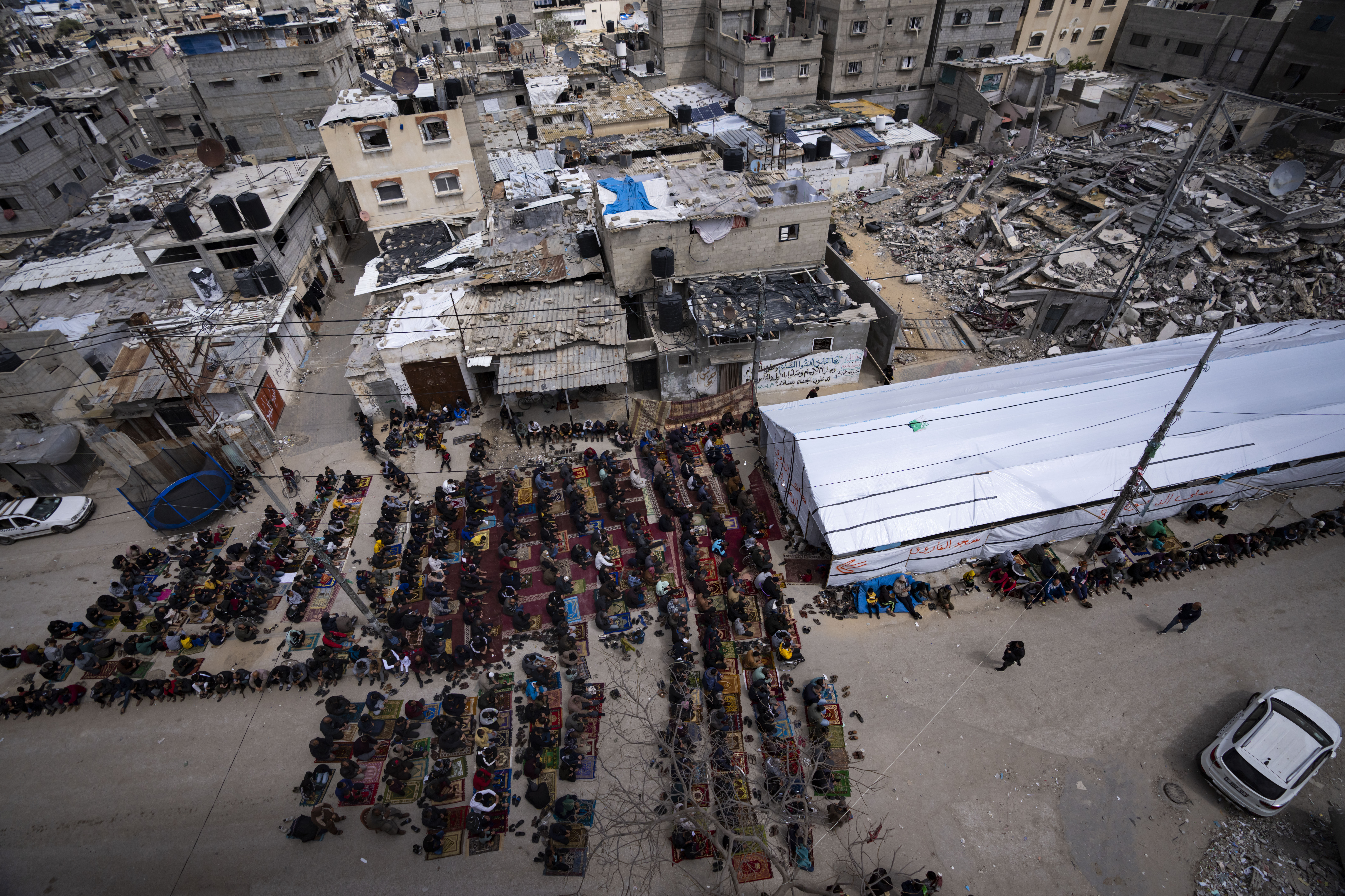 Palestinians perform Friday prayers of the Muslim holy month of Ramadan near the ruins of a destroyed mosque