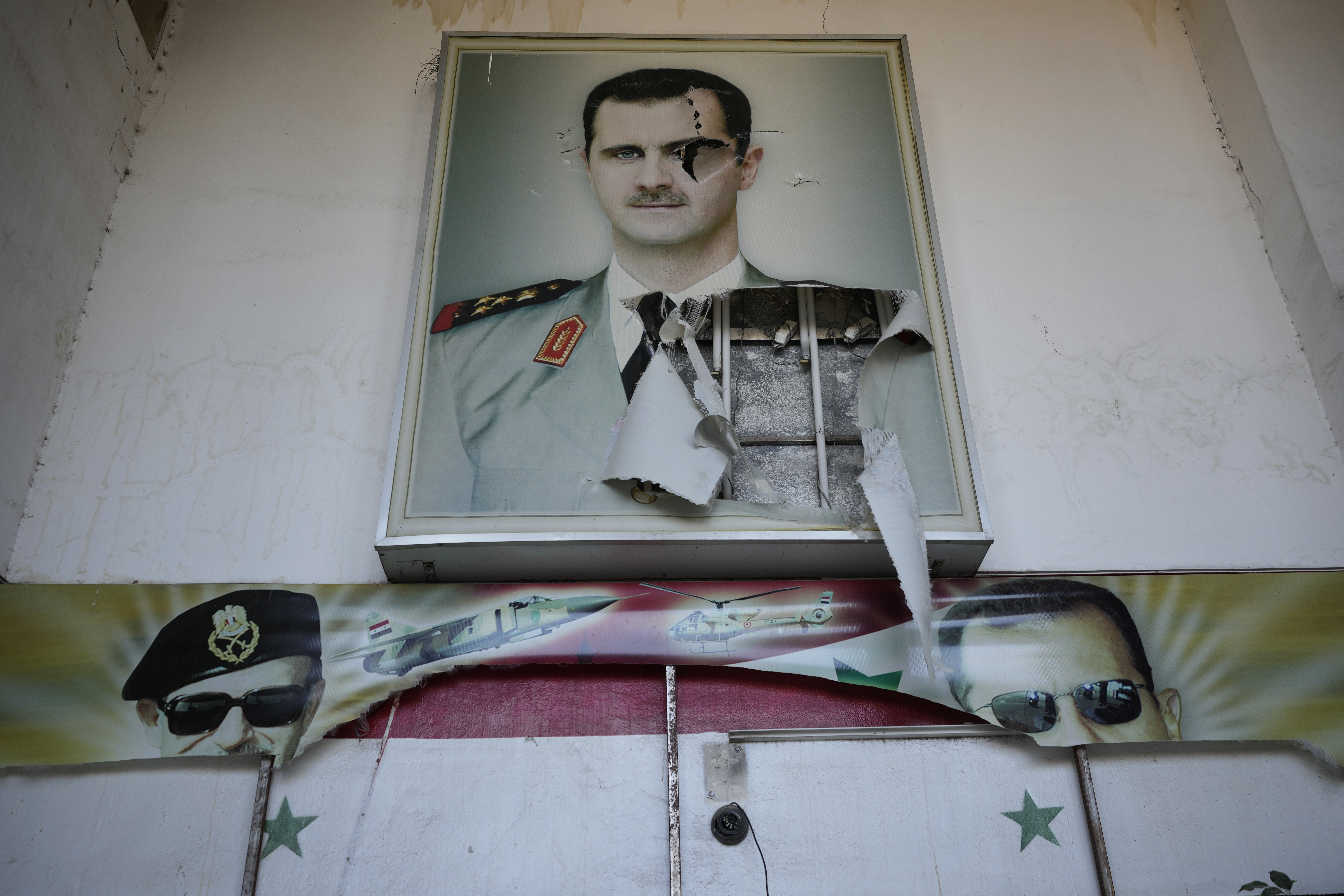 A torn posters shows the late Syrian President Hafez Assad