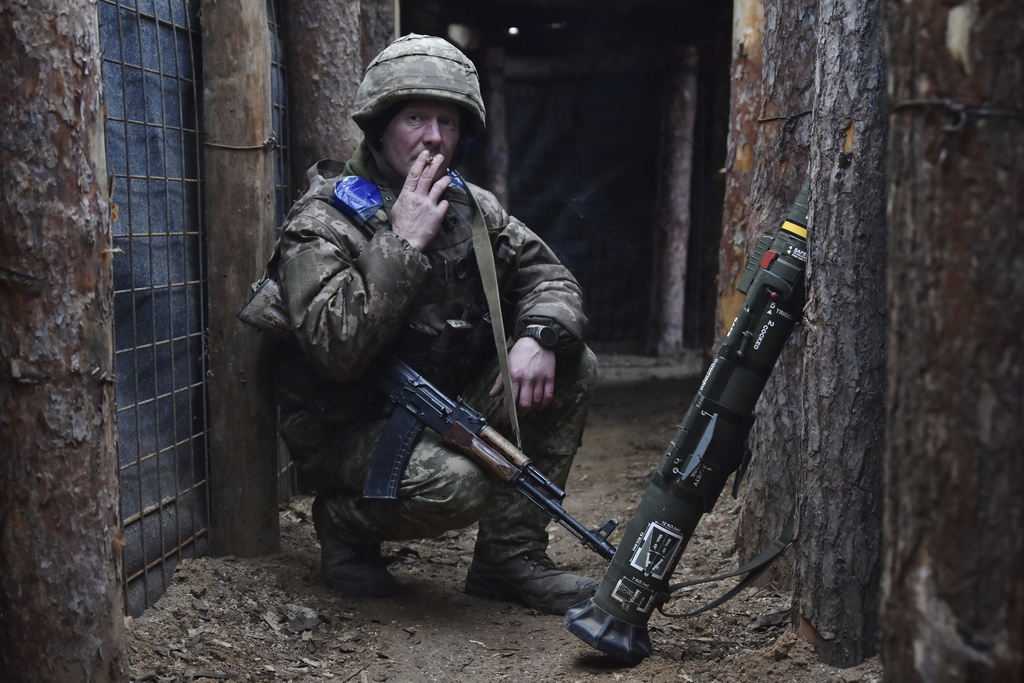 In this photo provided by Ukraine's 65th Mechanised Brigade press service, a Ukrainian soldier smokes in a trench on the frontline in Zaporizhzhia region, Ukraine, Tuesday, Dec. 31, 2024, (Andriy Andriyenko/Ukraine's 65th Mechanised Brigade via AP)