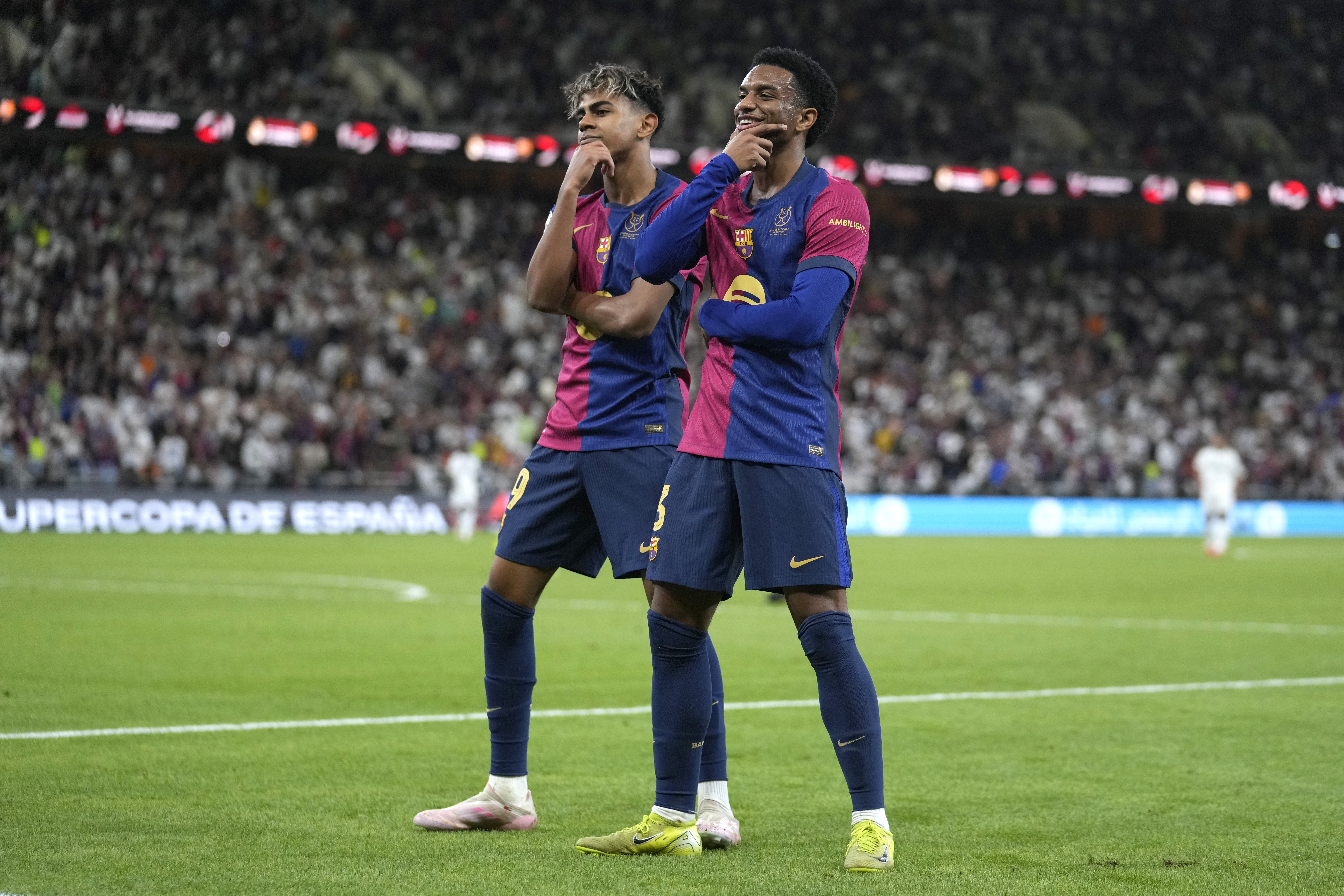 Barcelona's Alejandro Balde, right, and Barcelona's Lamine Yamal react during the Spain Super Cup final soccer match between Real Madrid and Barcelona at King Abdullah Stadium in Jeddah, Saudi Arabia, Sunday, Jan. 12, 2025. (AP Photo/Altaf Qadri)