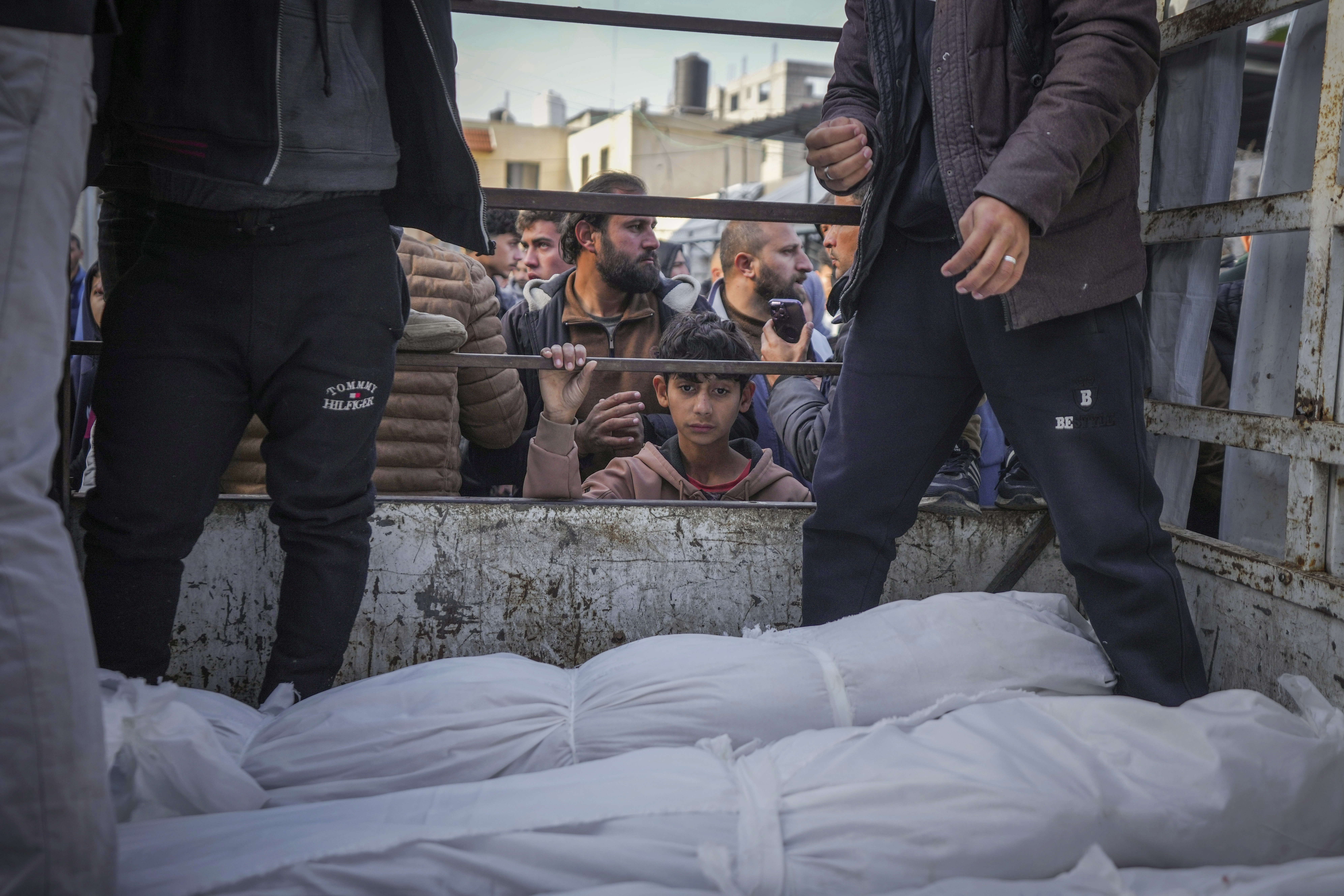 A boy looks at the bodies of Palestinians killed in the Israeli bombardment