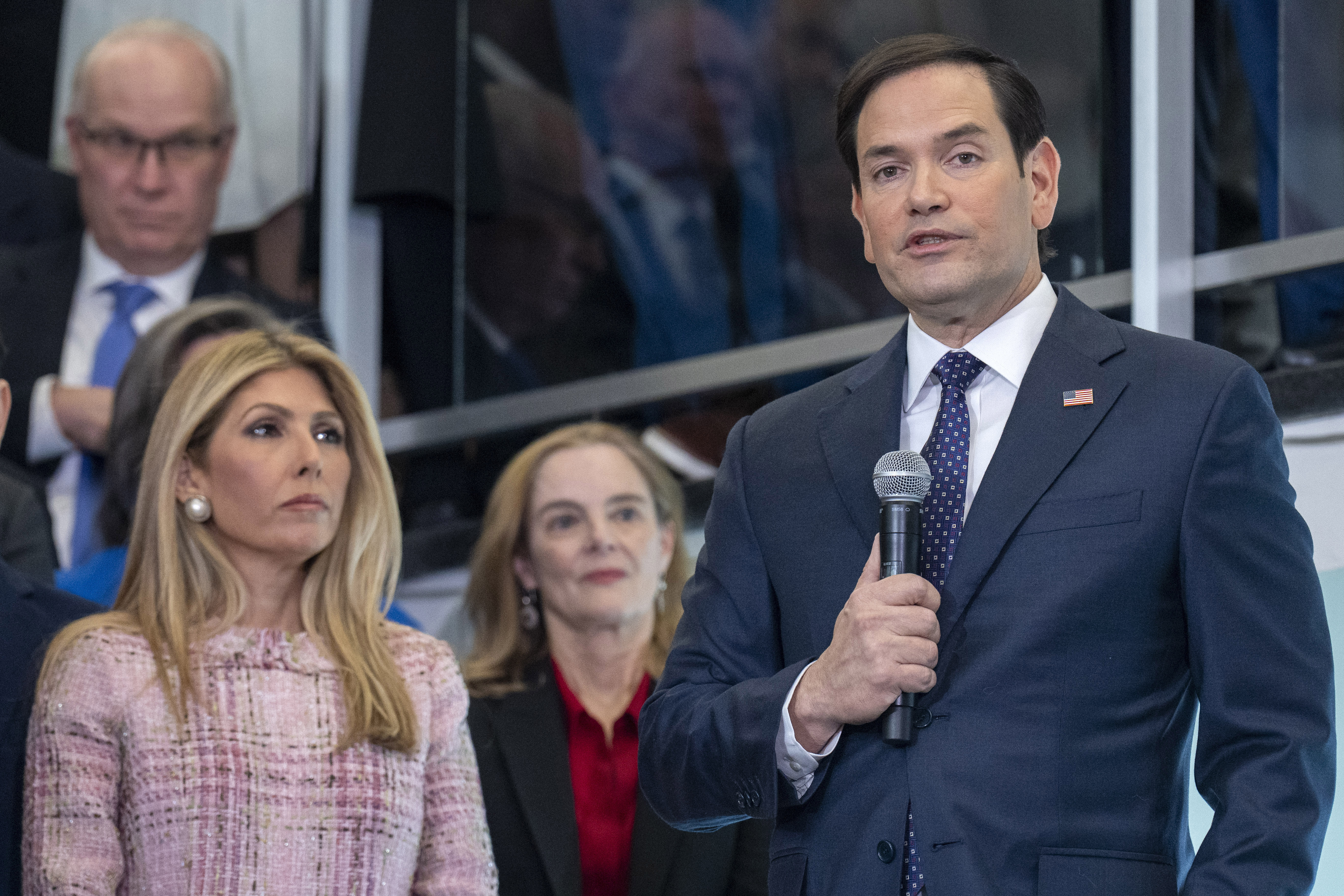 Marco Rubio stands next to his wife Jeanette as he speaks into a microphone.