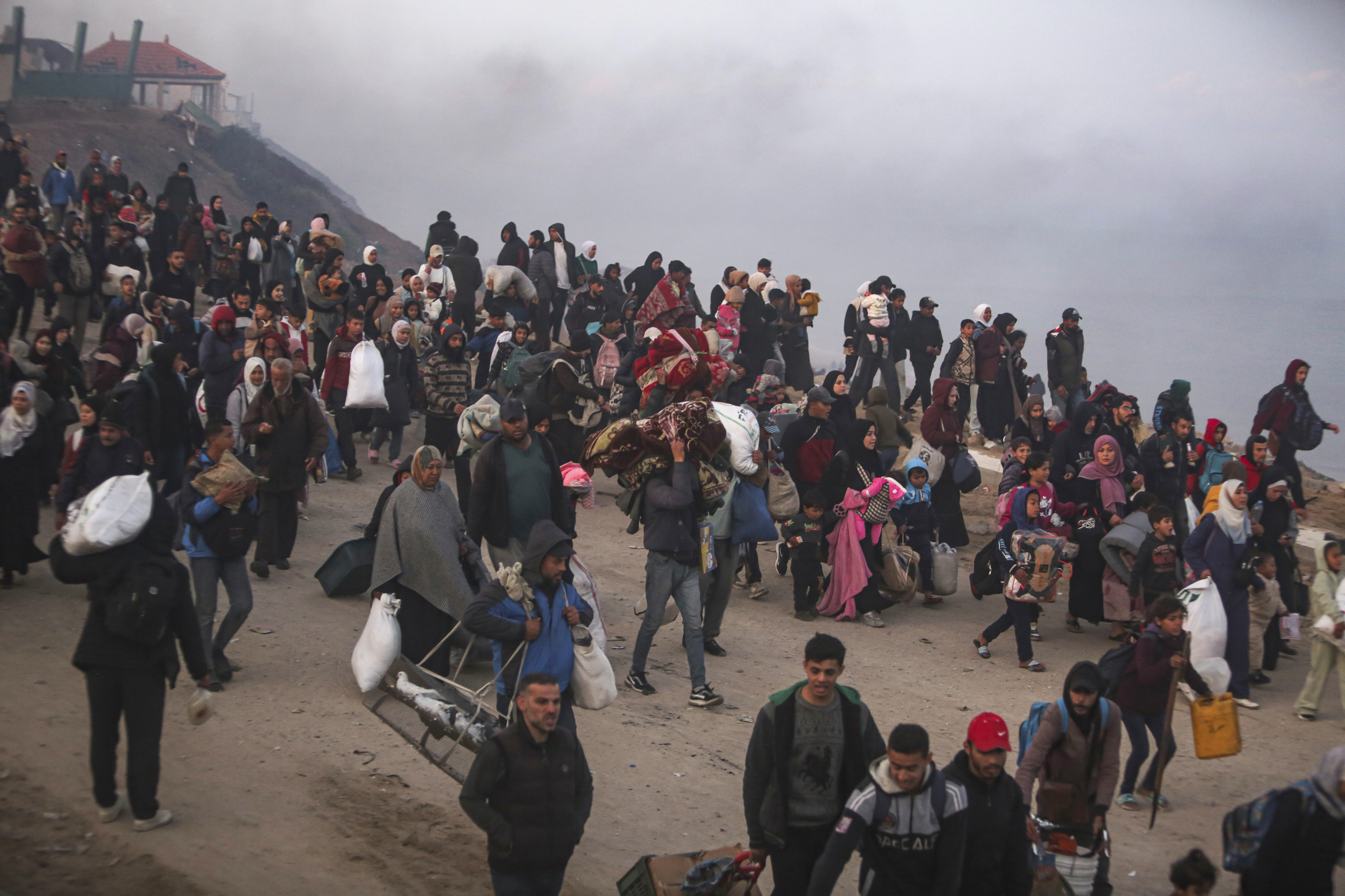 Palestinians walk back to their homes in northern Gaza