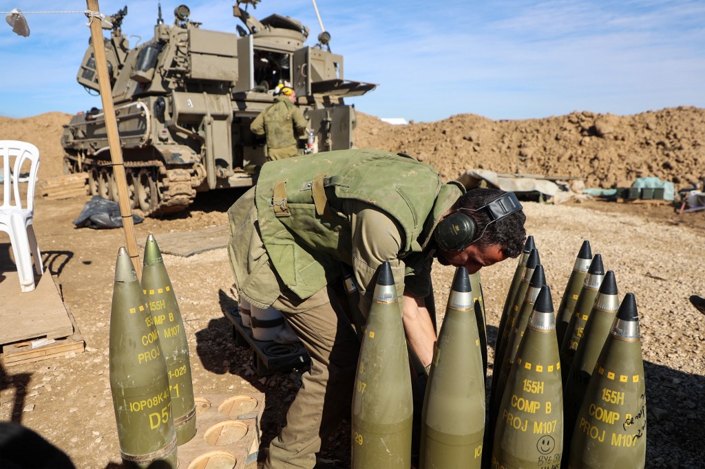 An Israeli soldier arranges shells