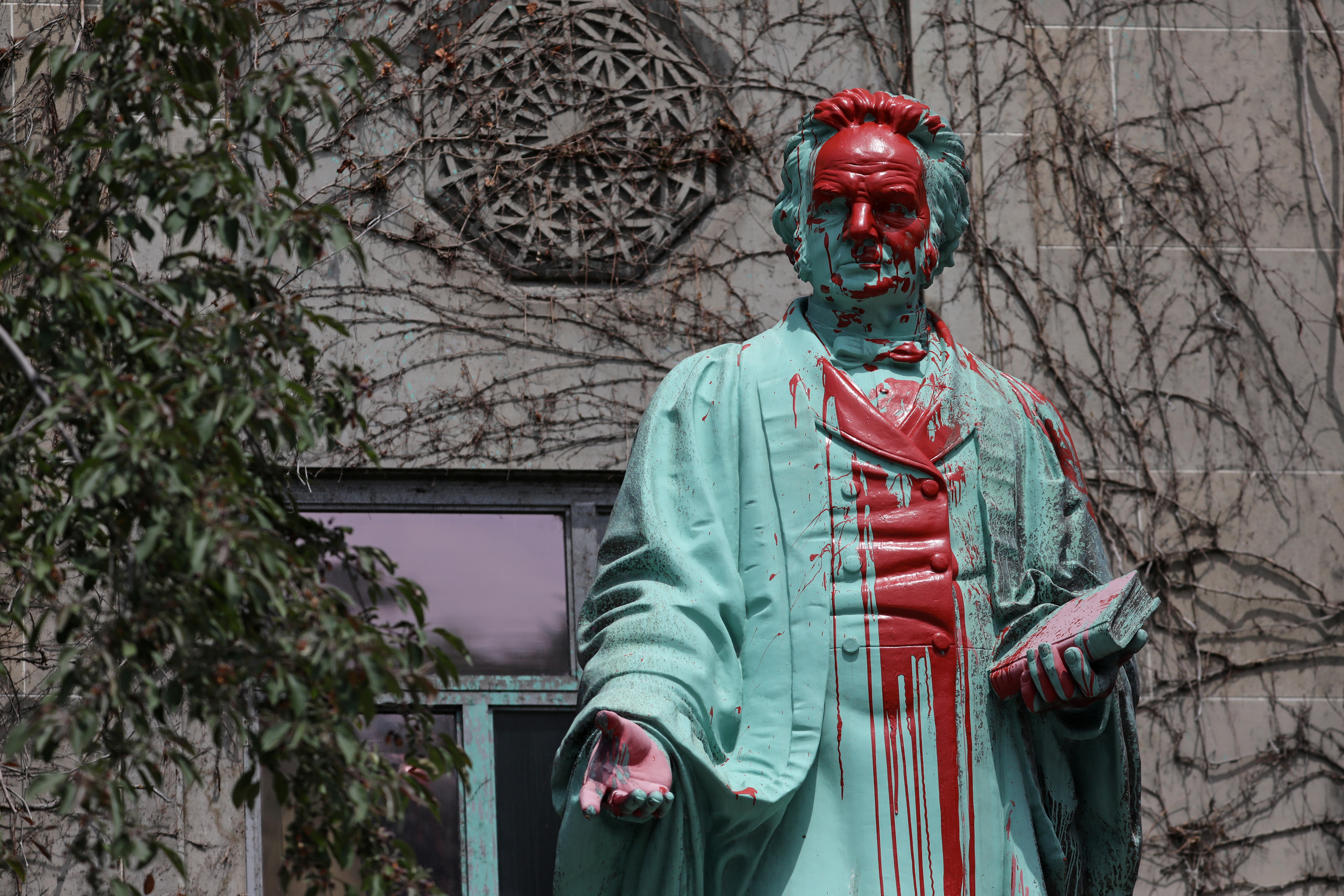 Red paint covers a defaced statue of Egerton Ryerson, a key architect of residential schools in Canada