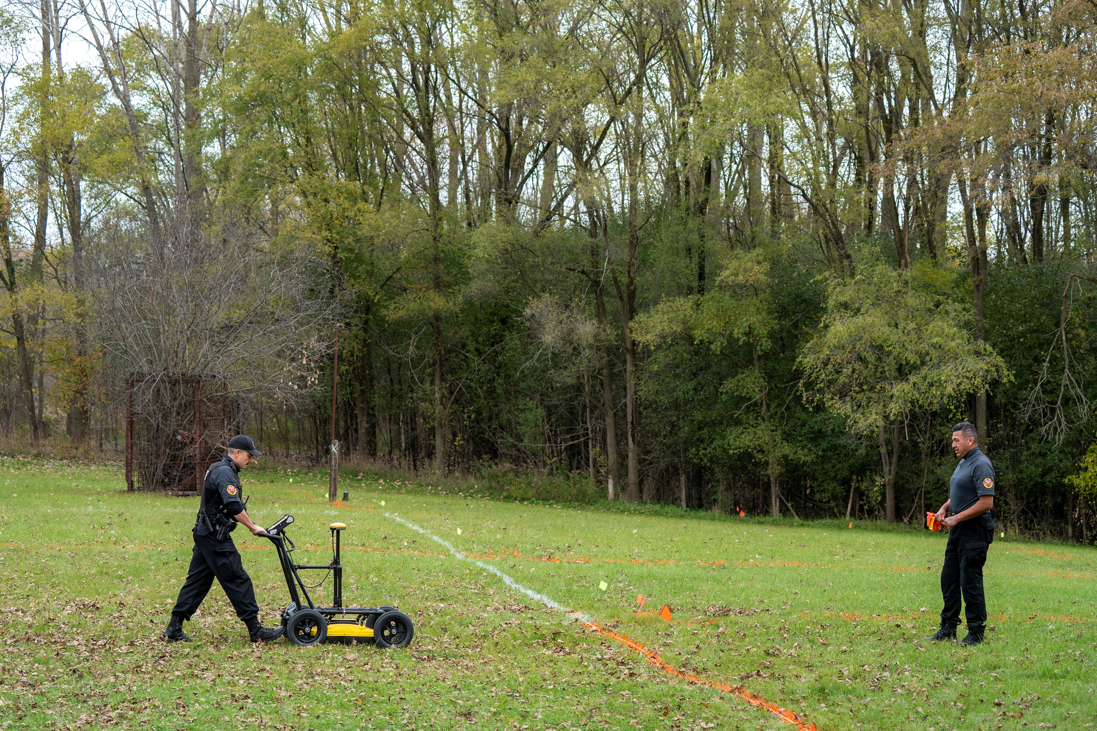 A police officer uses ground-penetrating radar in a search for unmarked graves