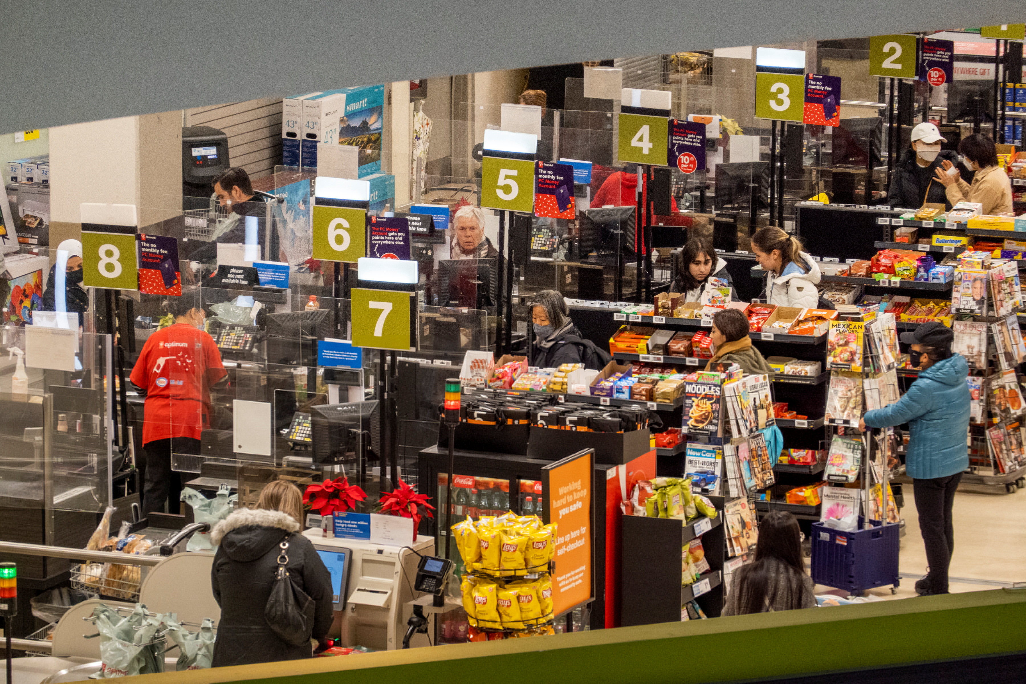 People pay for items at a grocery store in Toronto, Canada