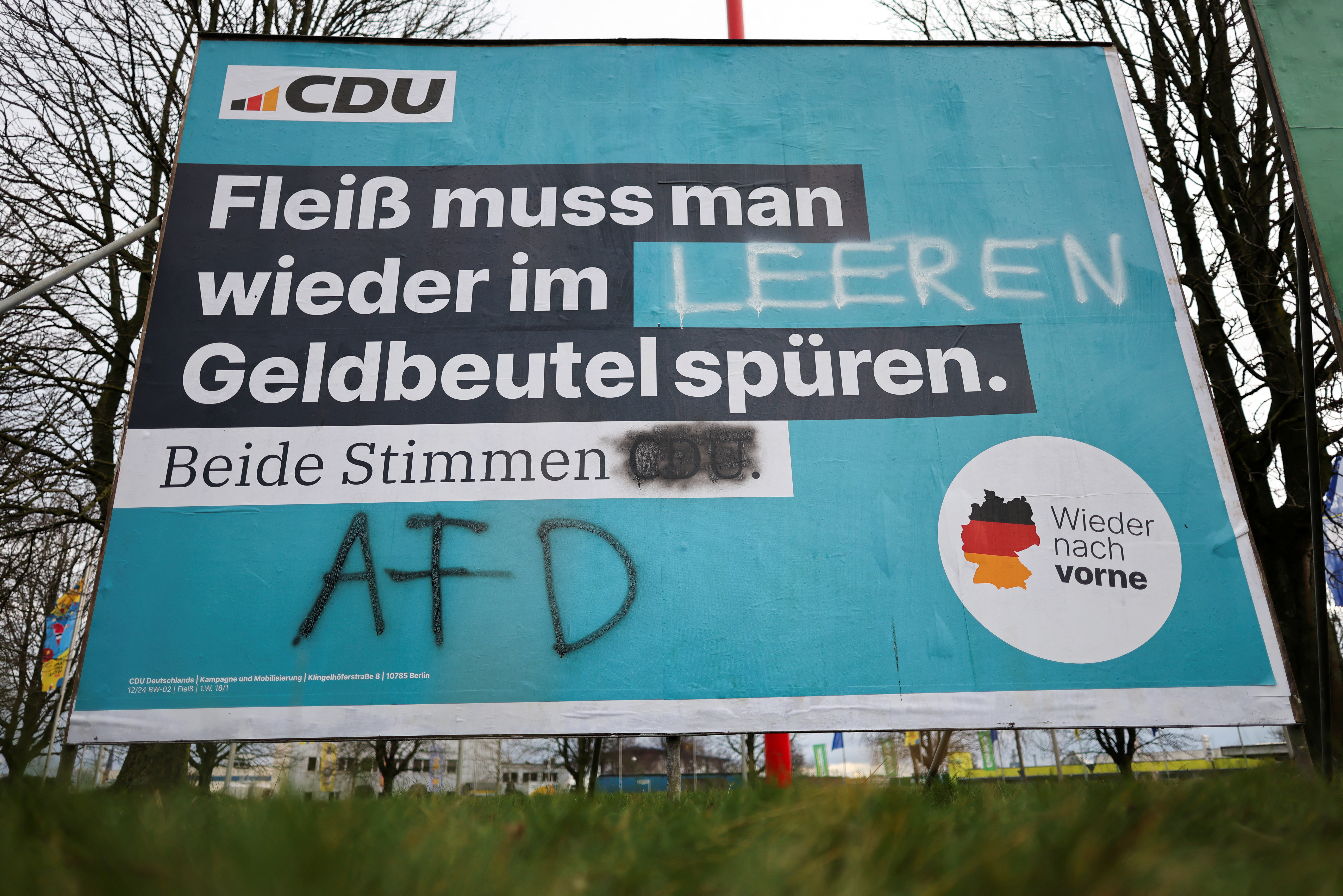 A placard of Germany's conservative Christian Democratic party CDU of candidate for Chancellor Friedrich Merz is seen besmeared in Bonn, Germany, January 23, 2025. The placard that originally read "Diligence must be felt in the wallet again. Both votes for CDU" has been altered to "Diligence must be felt in the empty wallet again. Both votes for AFD". REUTERS/Wolfgang Rattay