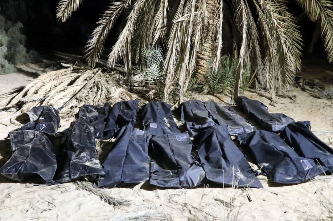 Bodies of migrants lie in bags.