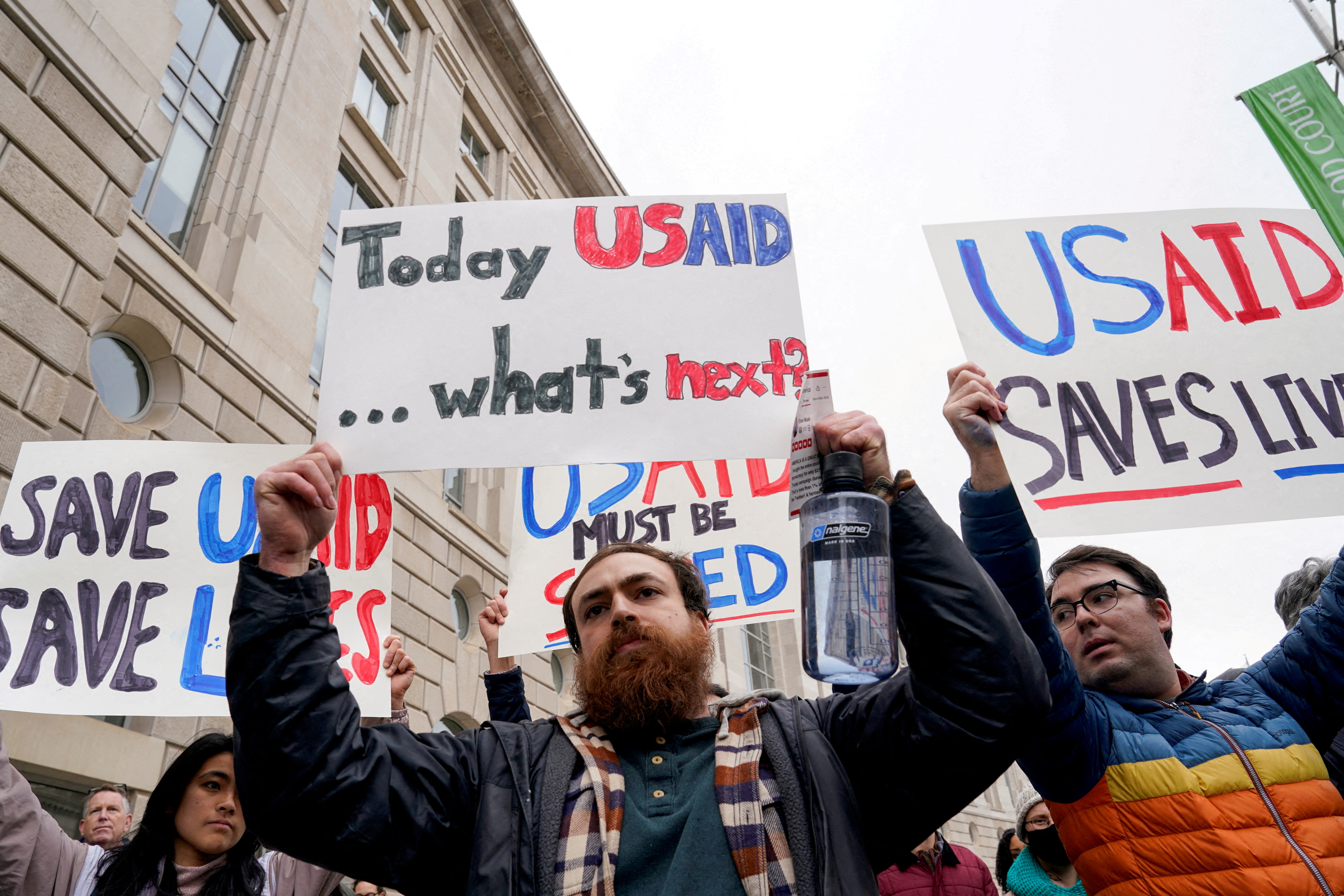 FILE PHOTO: People hold placards outside the USAID building, after billionaire Elon Musk, who is heading U.S. President Donald Trump's drive to shrink the federal government, said work is underway to shut down the U.S. foreign aid agency USAID, in Washington, U.S., February 3, 2025. REUTERS/Kent Nishimura/File Photo