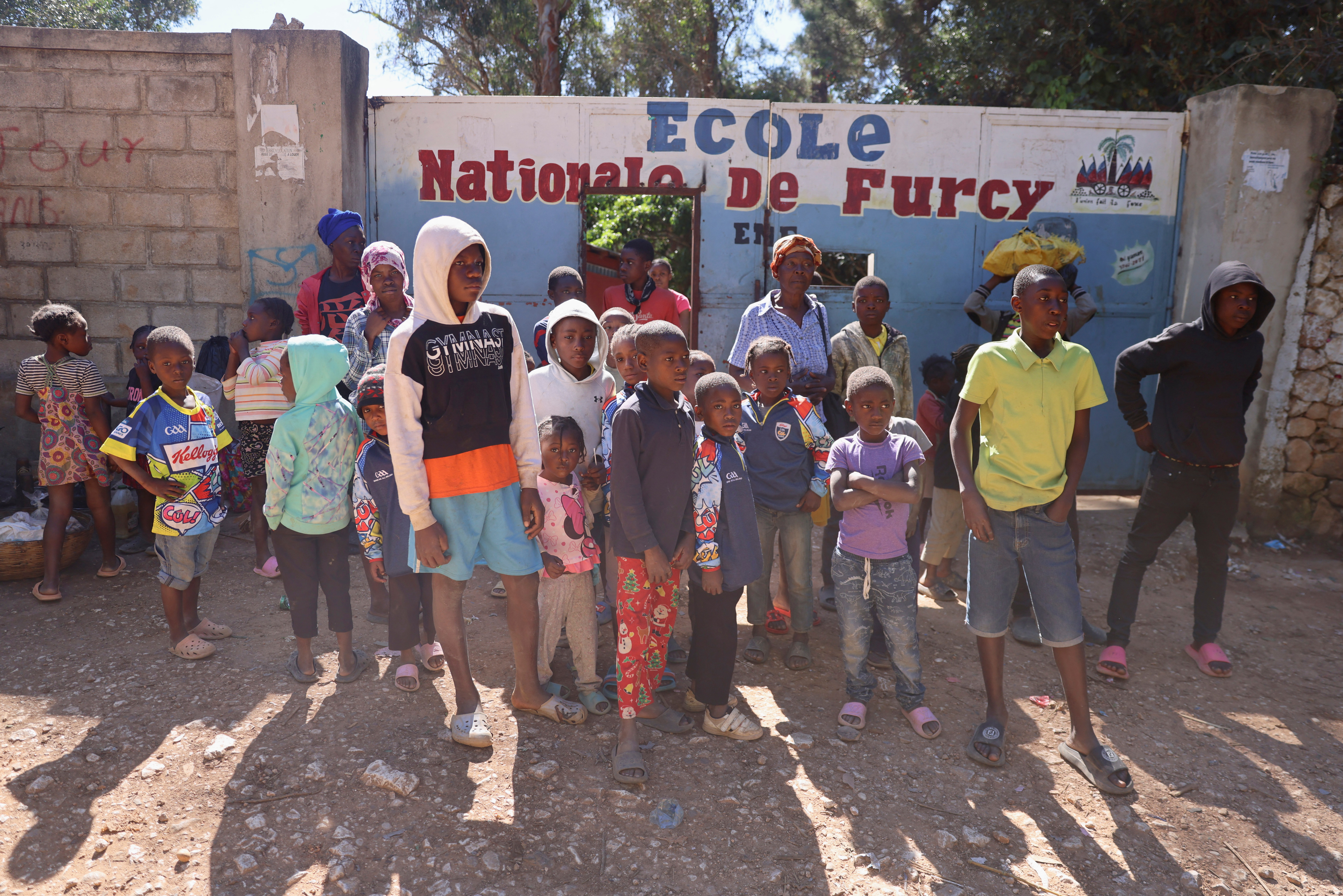 Internally displaced people stand outside of the "Ecole National de Furcy", which is used as a refuge after gang violence, in Port-au-Prince, Haiti, February 10, 2025. REUTERS/Ralph Tedy Erol