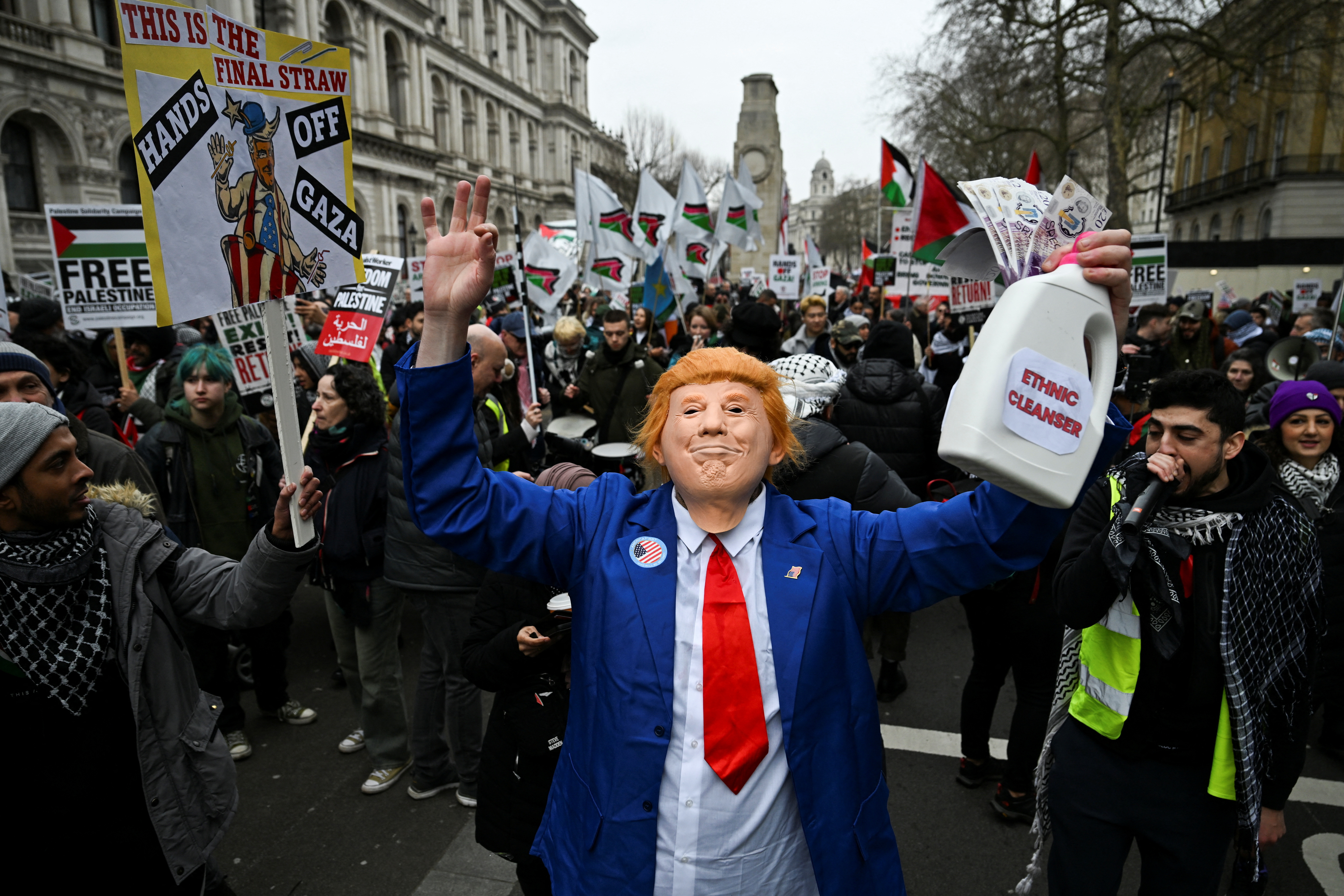 A man wears a mask depicting U.S. President Donald Trump as pro-Palestinian demonstrators attend a march in opposition to U.S President Donald Trump's plan to displace Palestinians from Gaza and "take over" the territory, in London, Britain February 15, 2025. [Chris J. Ratcliffe/Reuters]